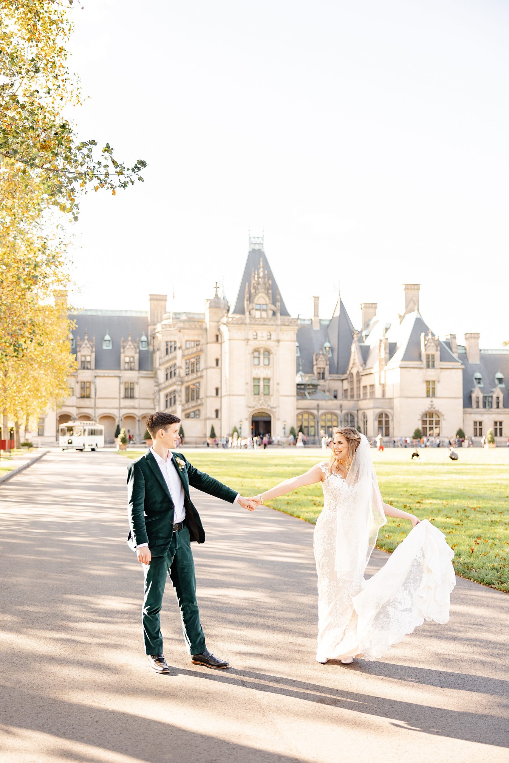 bride and groom hold hands walking outside the Biltmore Estate