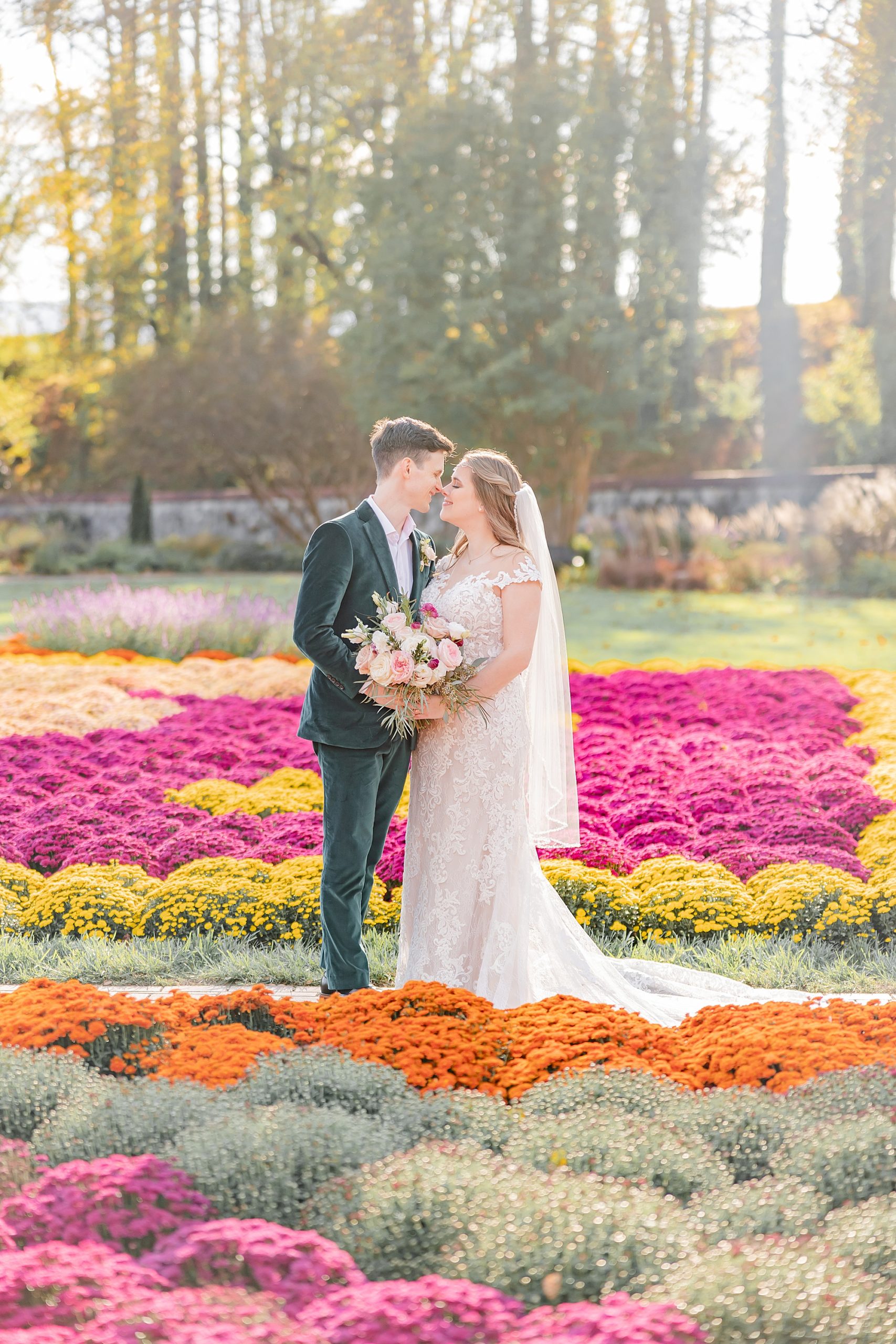 bride and groom stand in front of colorful flowers at the Biltmore