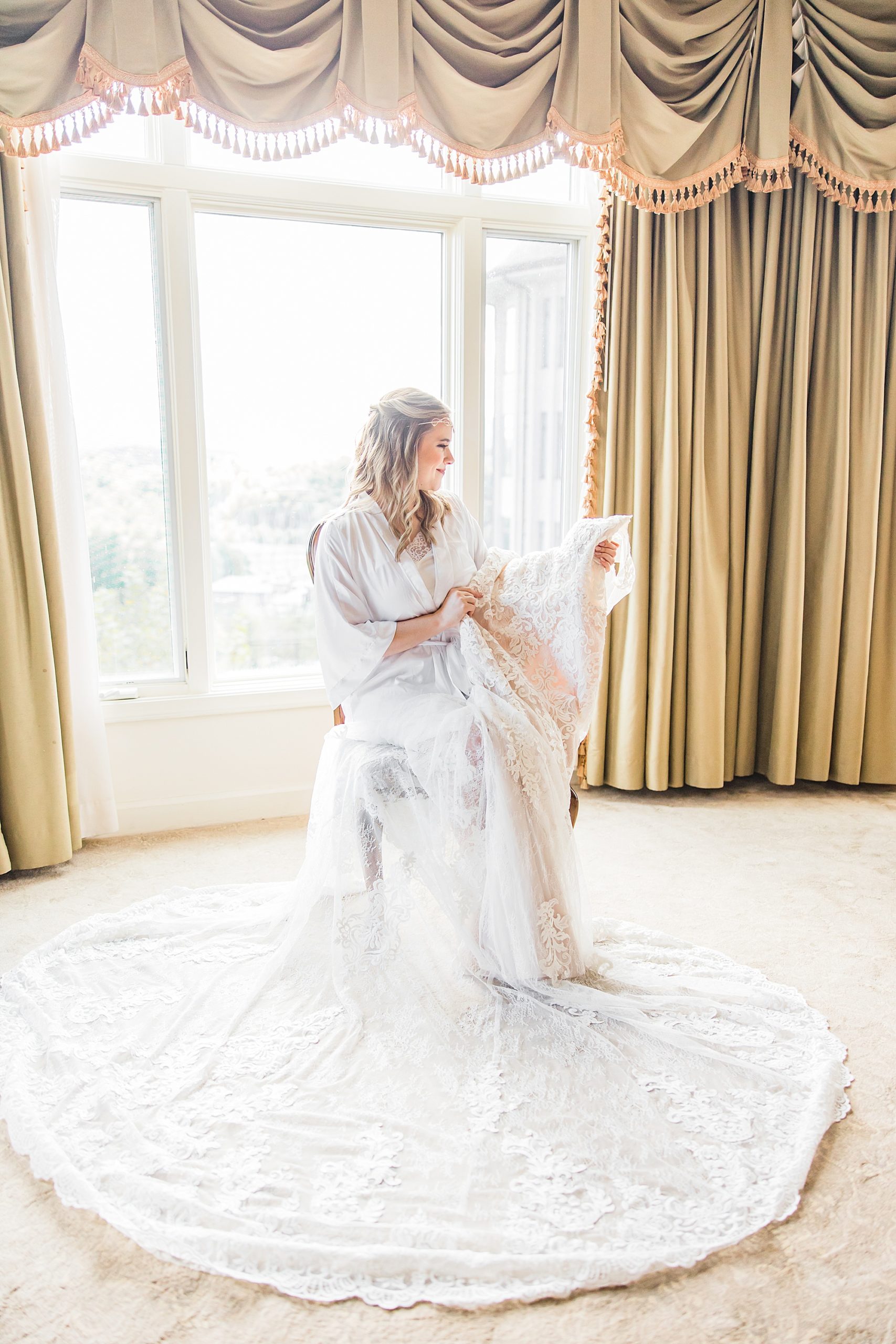 bride looks at veil on wedding morning 