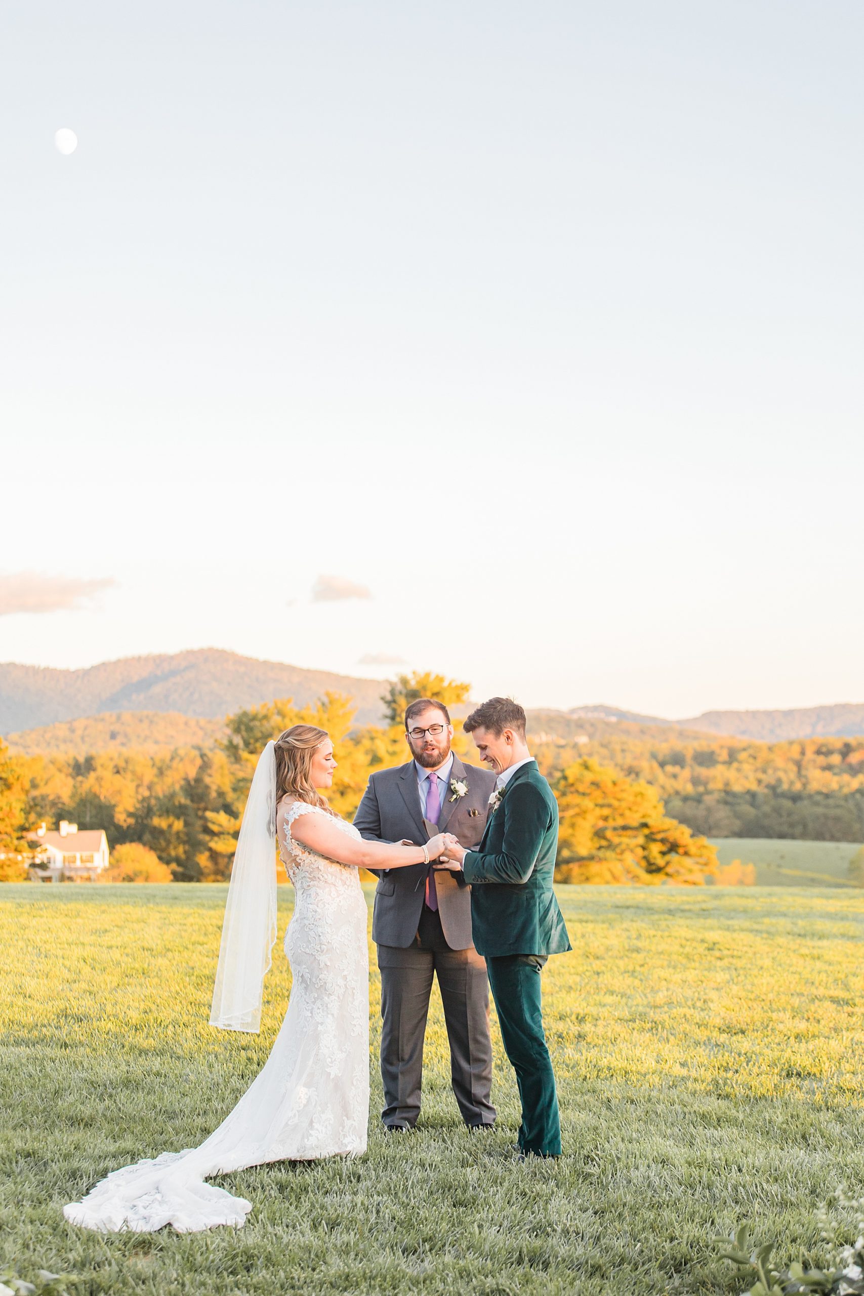 groom holds bride's hands during Asheville NC outdoor wedding ceremony
