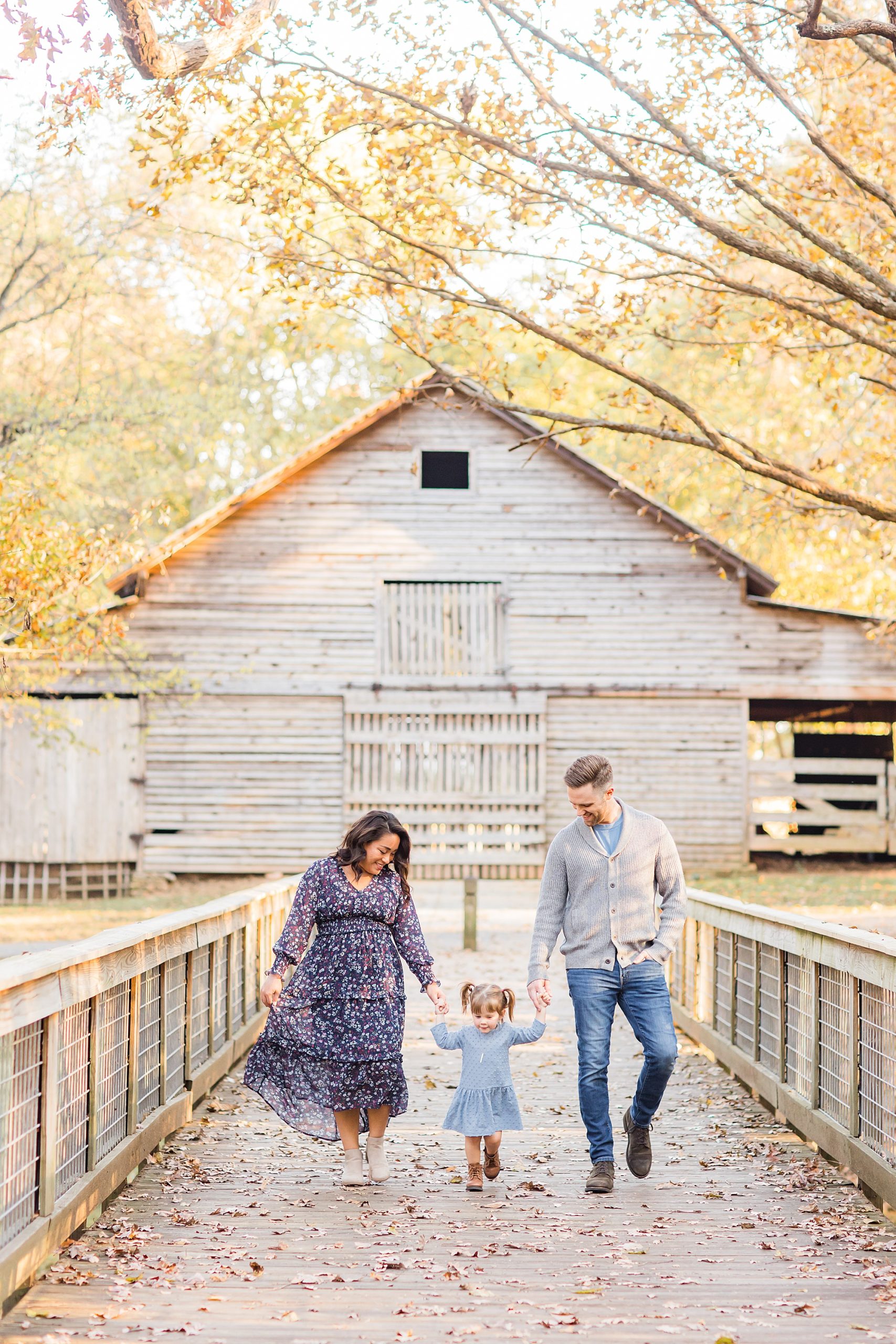 family of three walks by barn in Duluth GA park