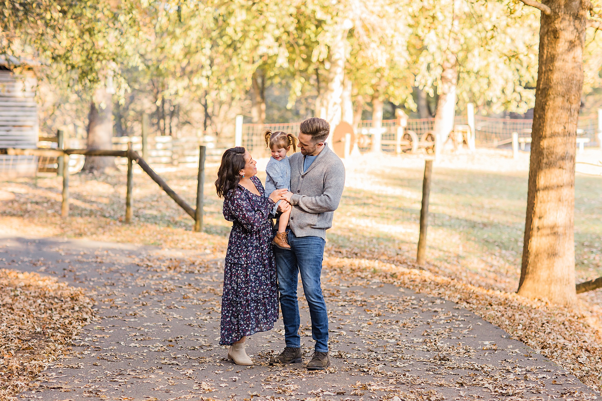 family of three hugs during fall portraits in GA