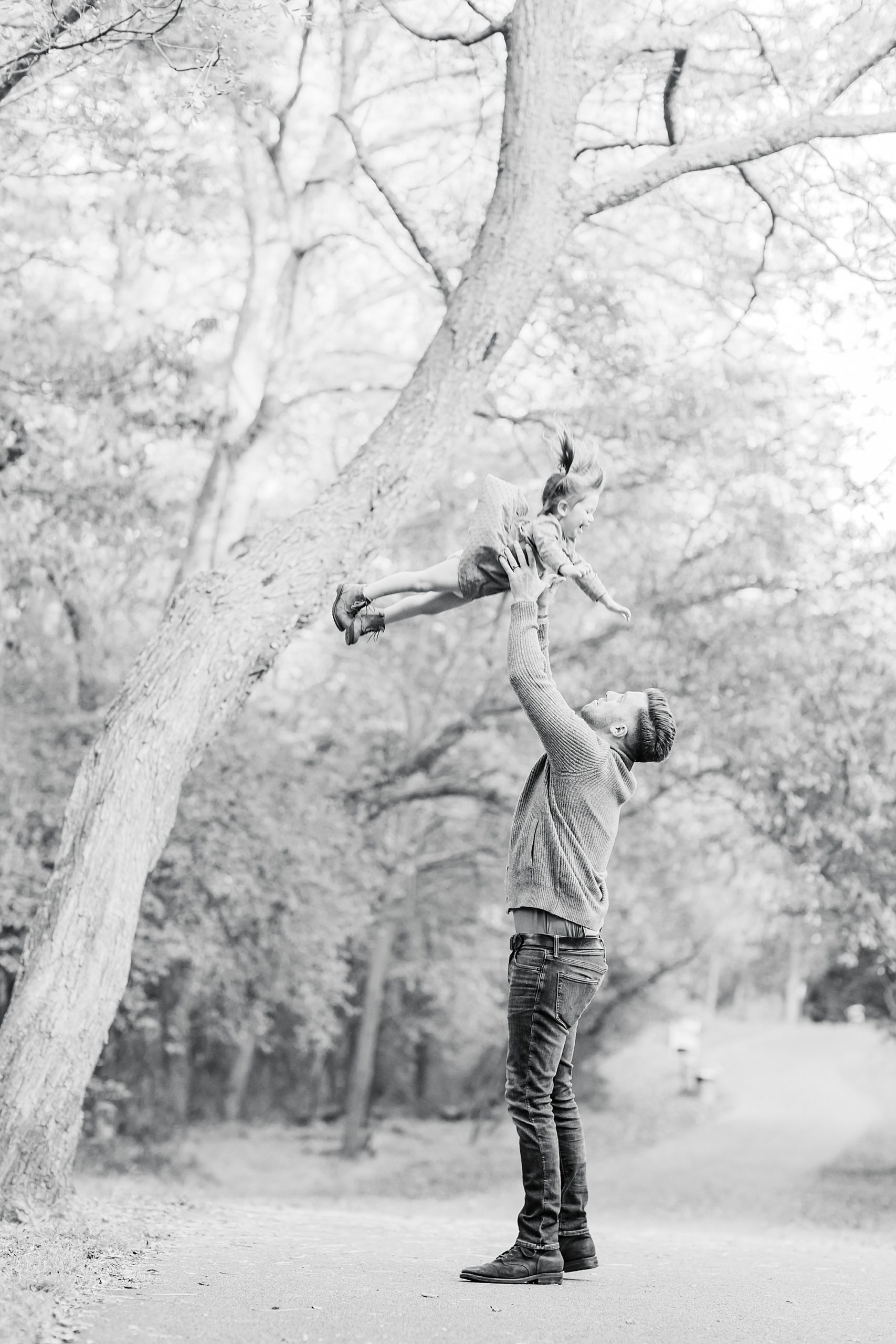 dad tosses daughter in the air during fall family photos