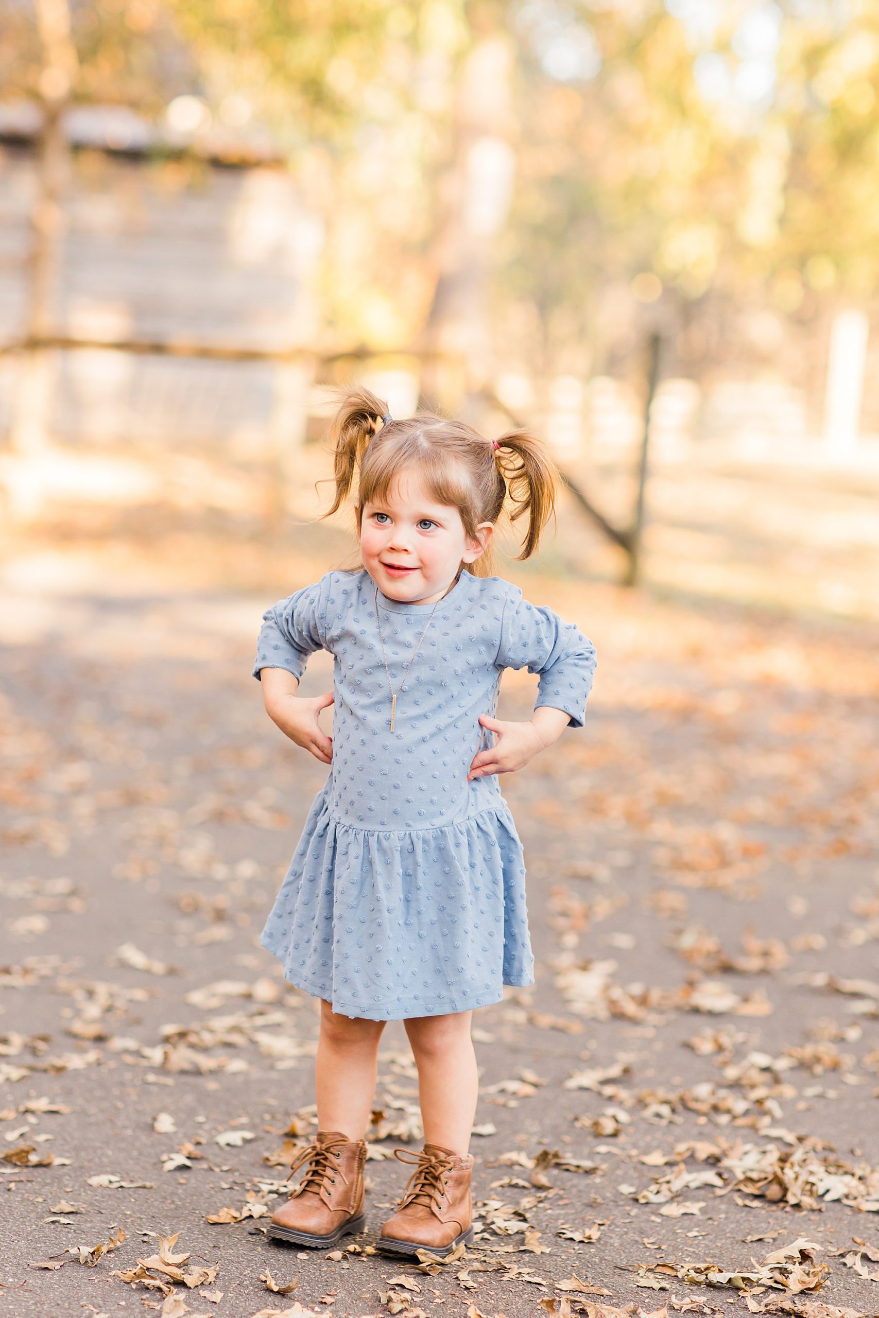 toddler in blue dress giggles during family photos