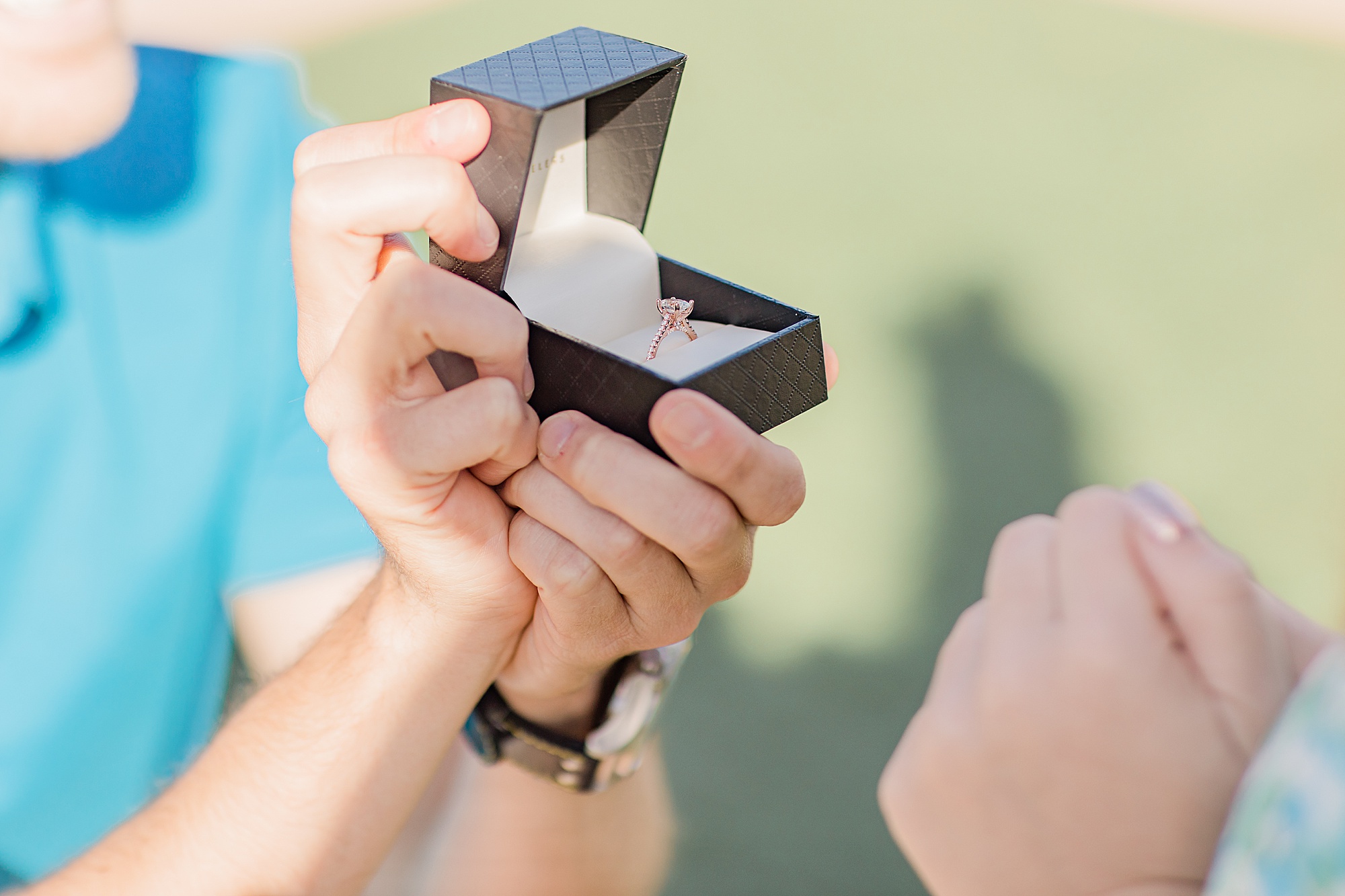 groom shows bride engagement ring after proposal 