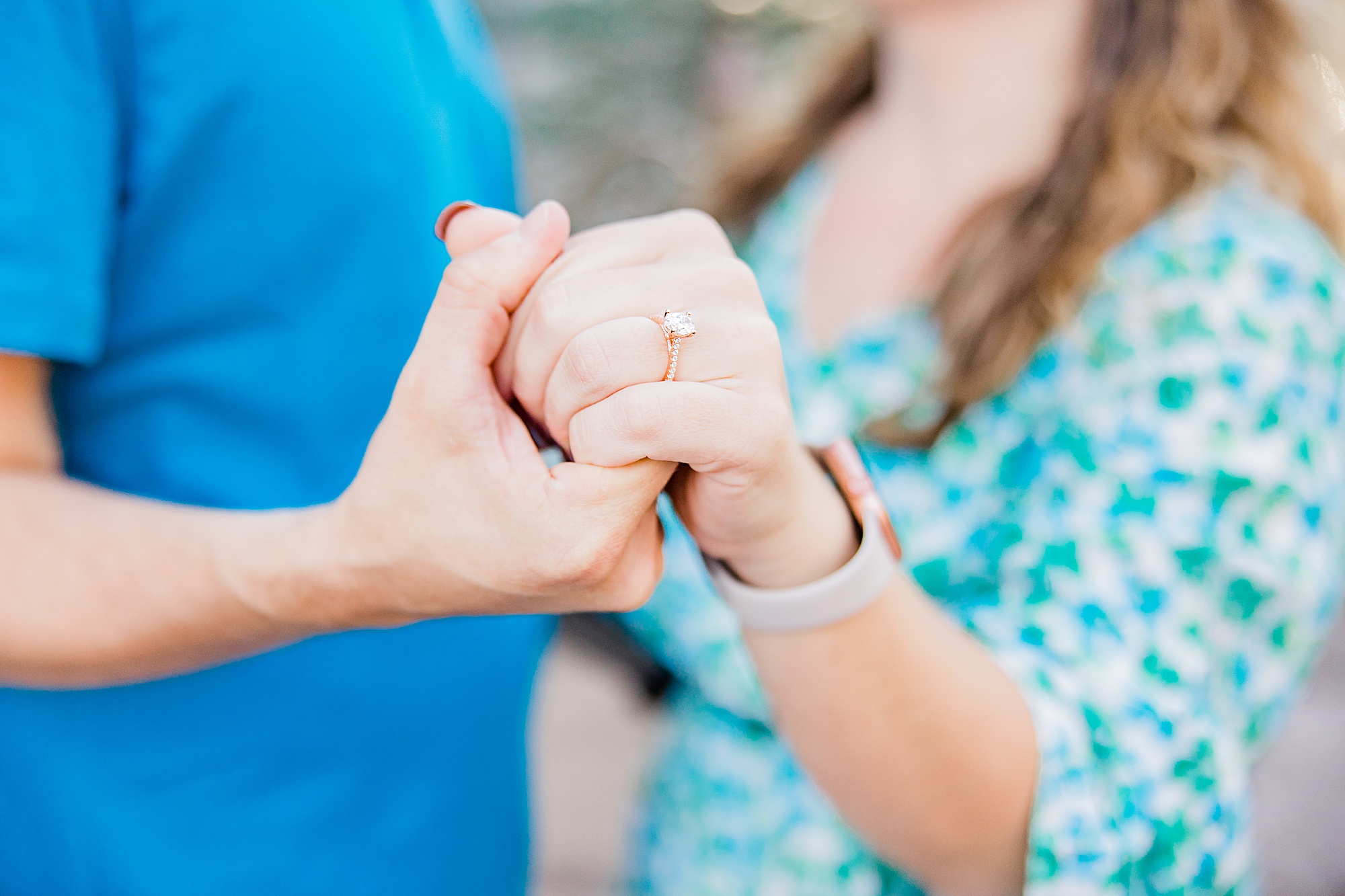 groom holds out bride's hand with ring in Magic Kingdom