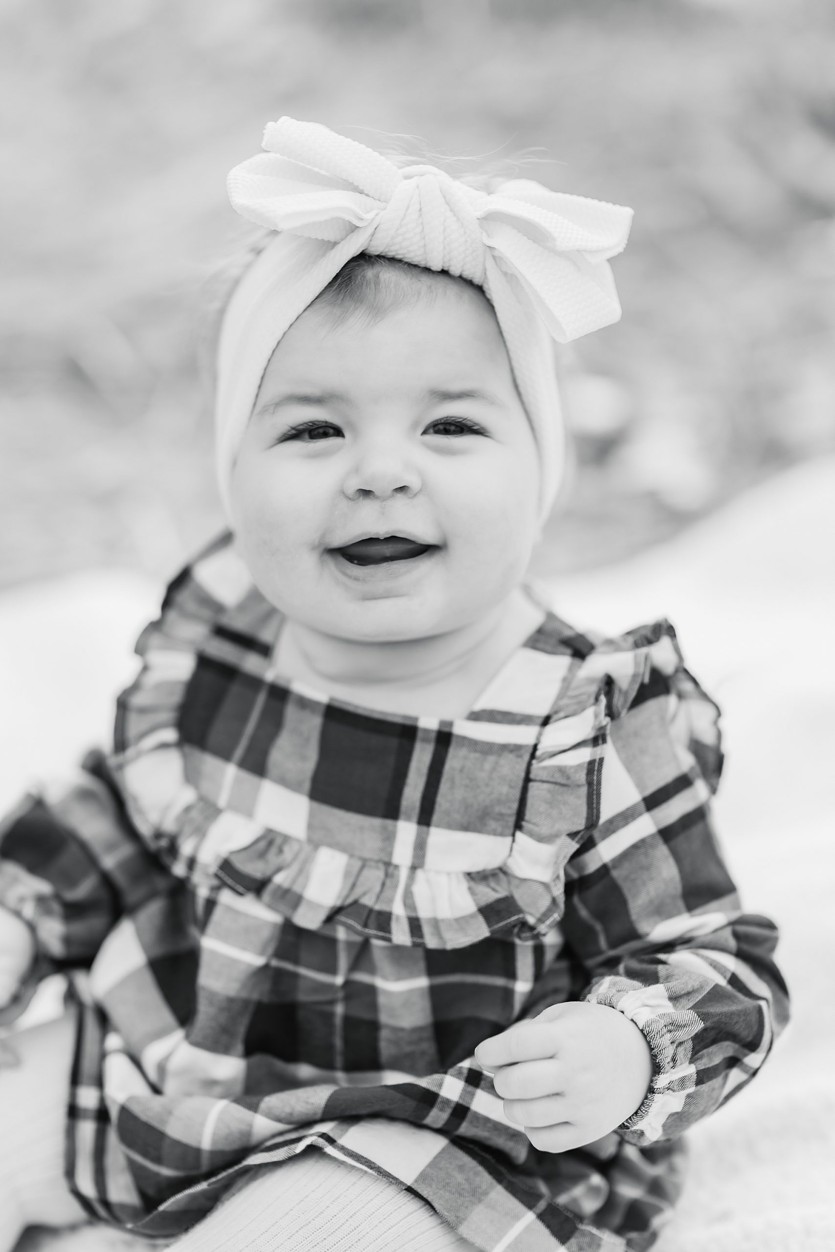 toddler girl in holiday dress laughs during family photos