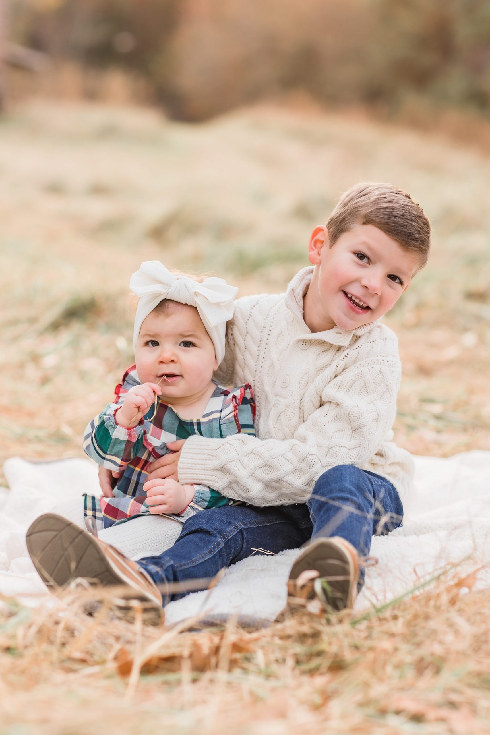 bother holds his sister on blanket during family session in Lancaster SC