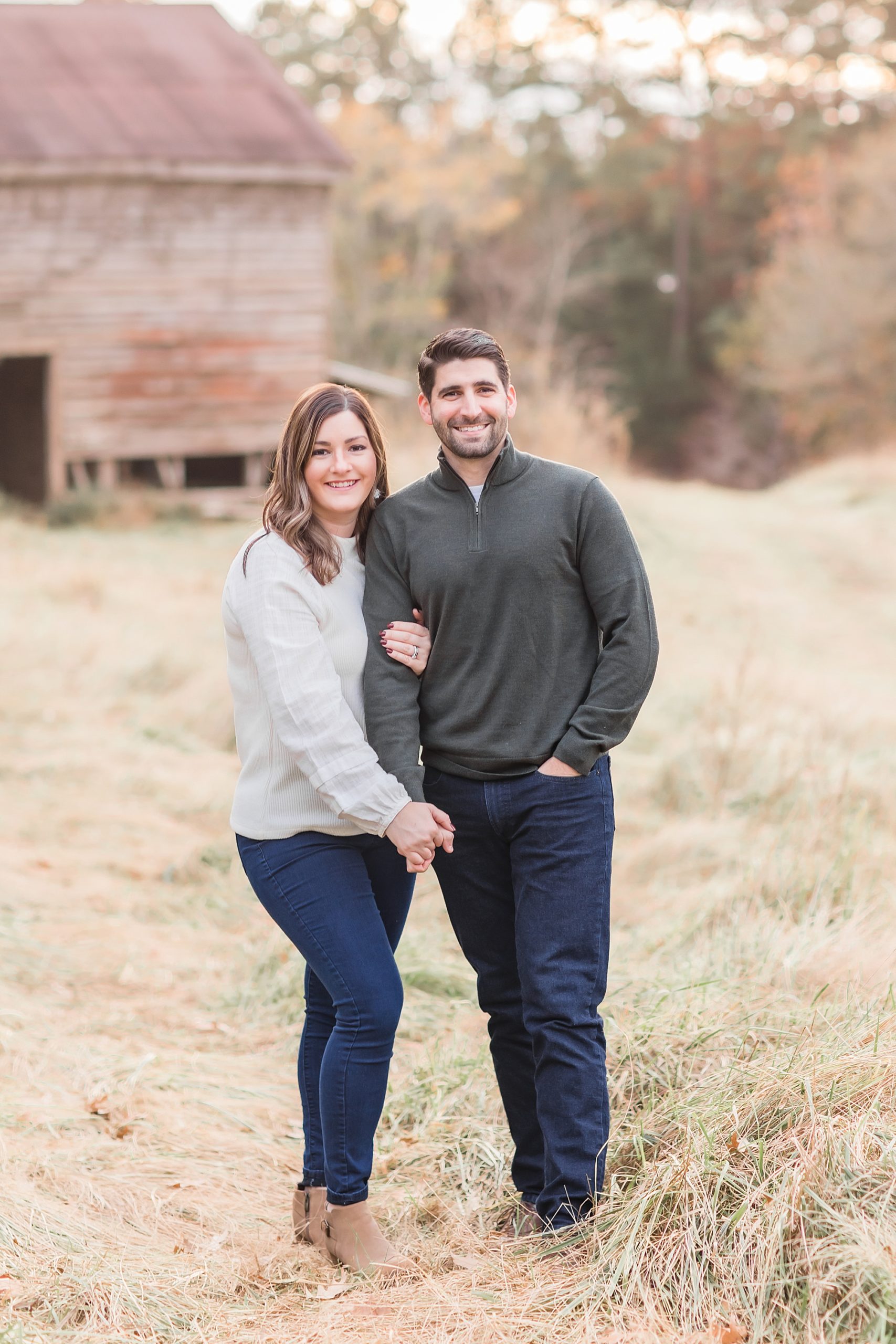couple holds hands standing in field during The Ivy Place Venue family portraits
