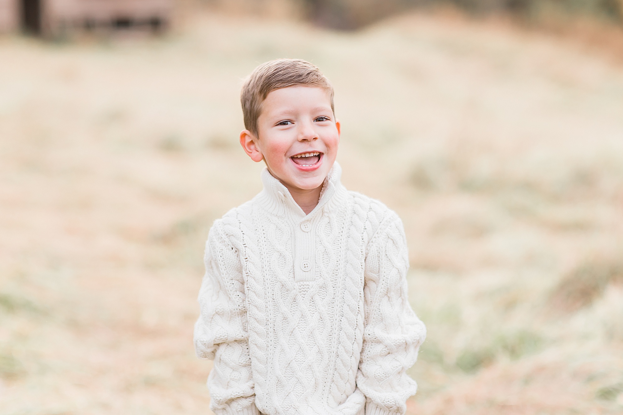 toddler in white sweater laughs during The Ivy Place Venue family portraits