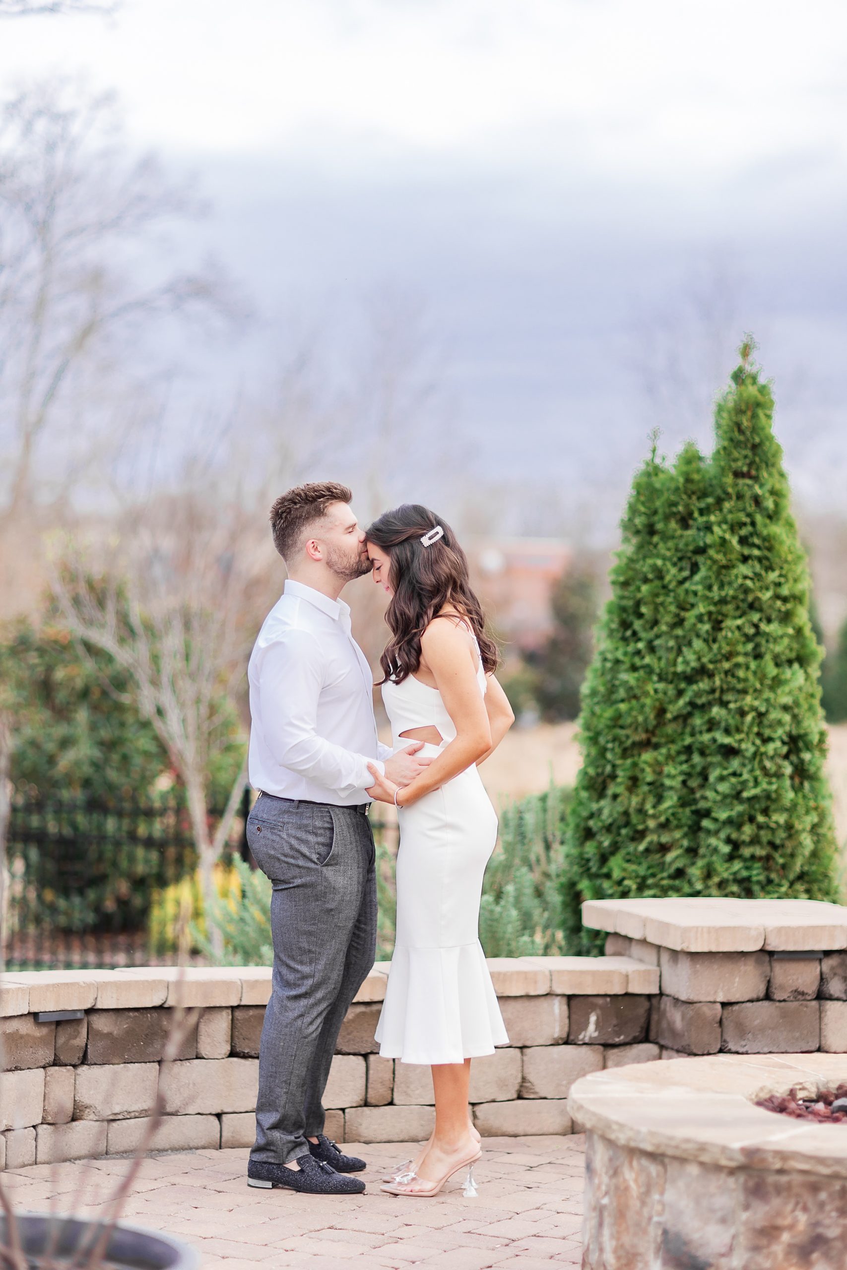 groom kisses bride's forehead during first look at home