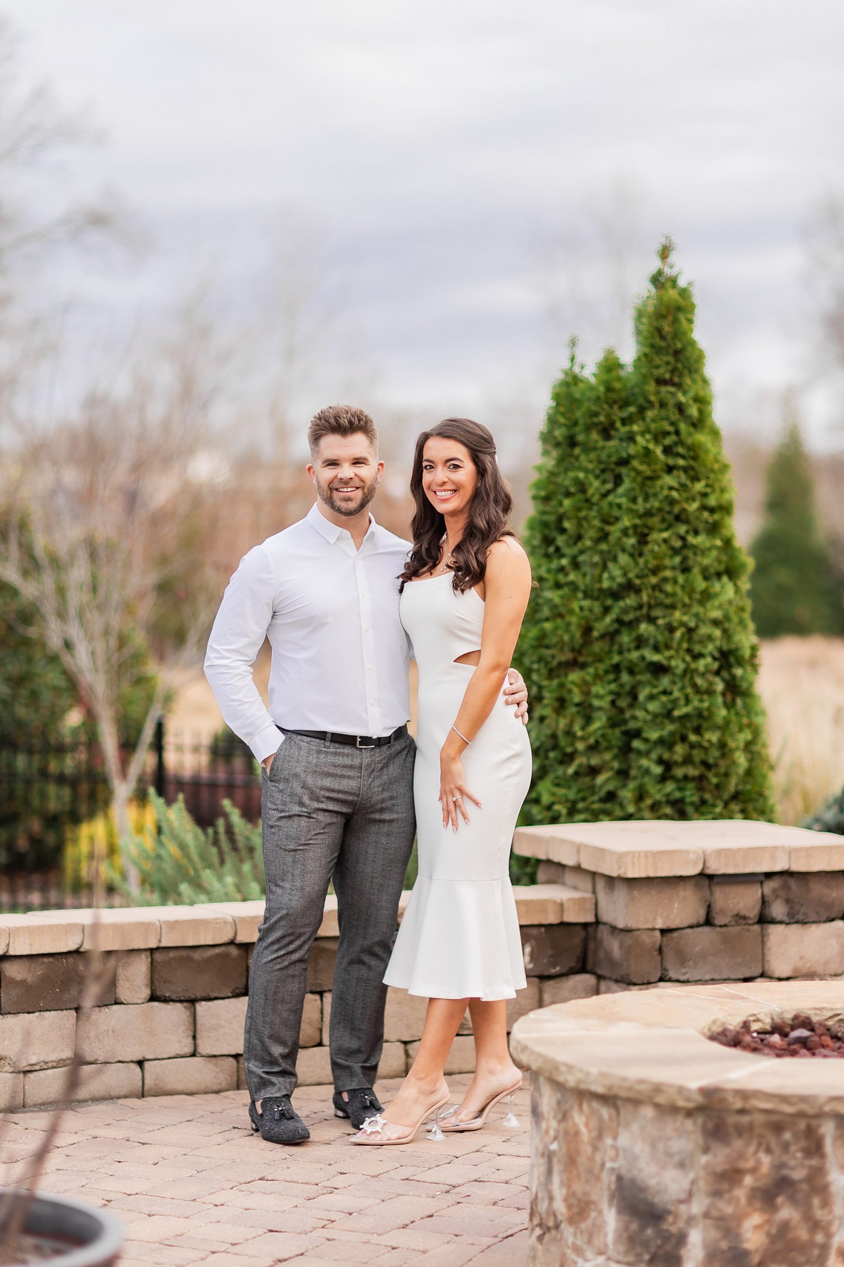 newlyweds stand together on brick patio at home