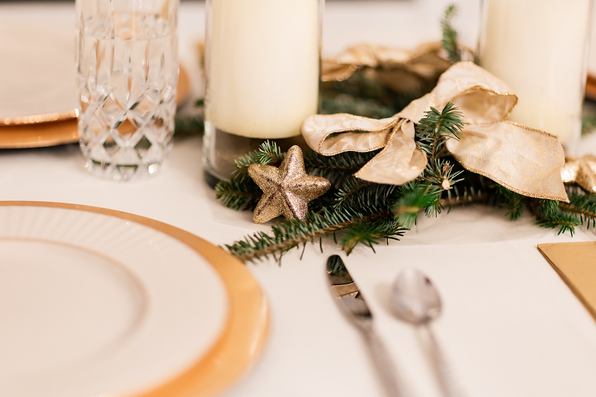 place setting with greenery and pillar candles for New Year's Eve wedding