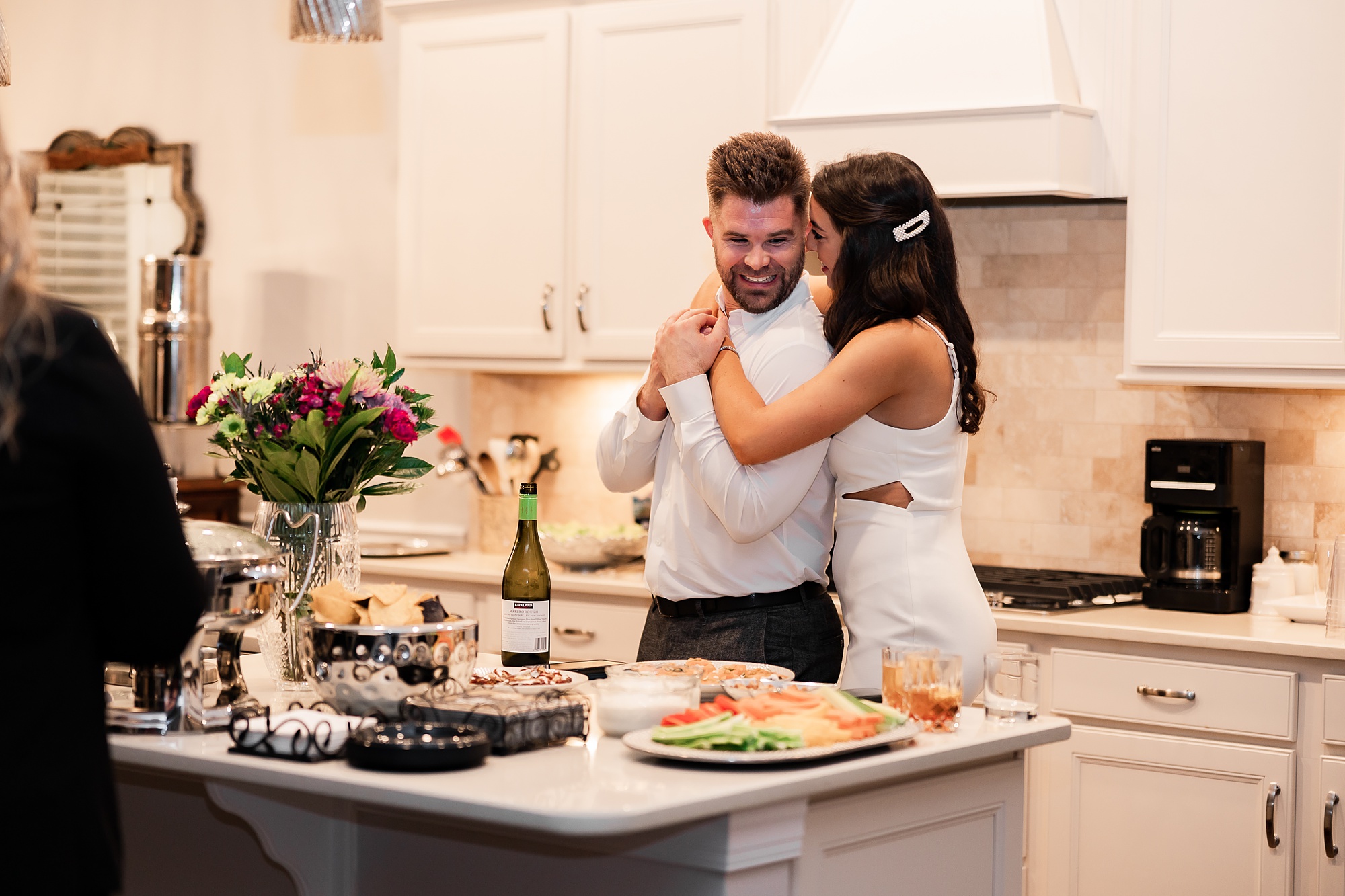 bride hugs groom in kitchen after intimate at-home elopement