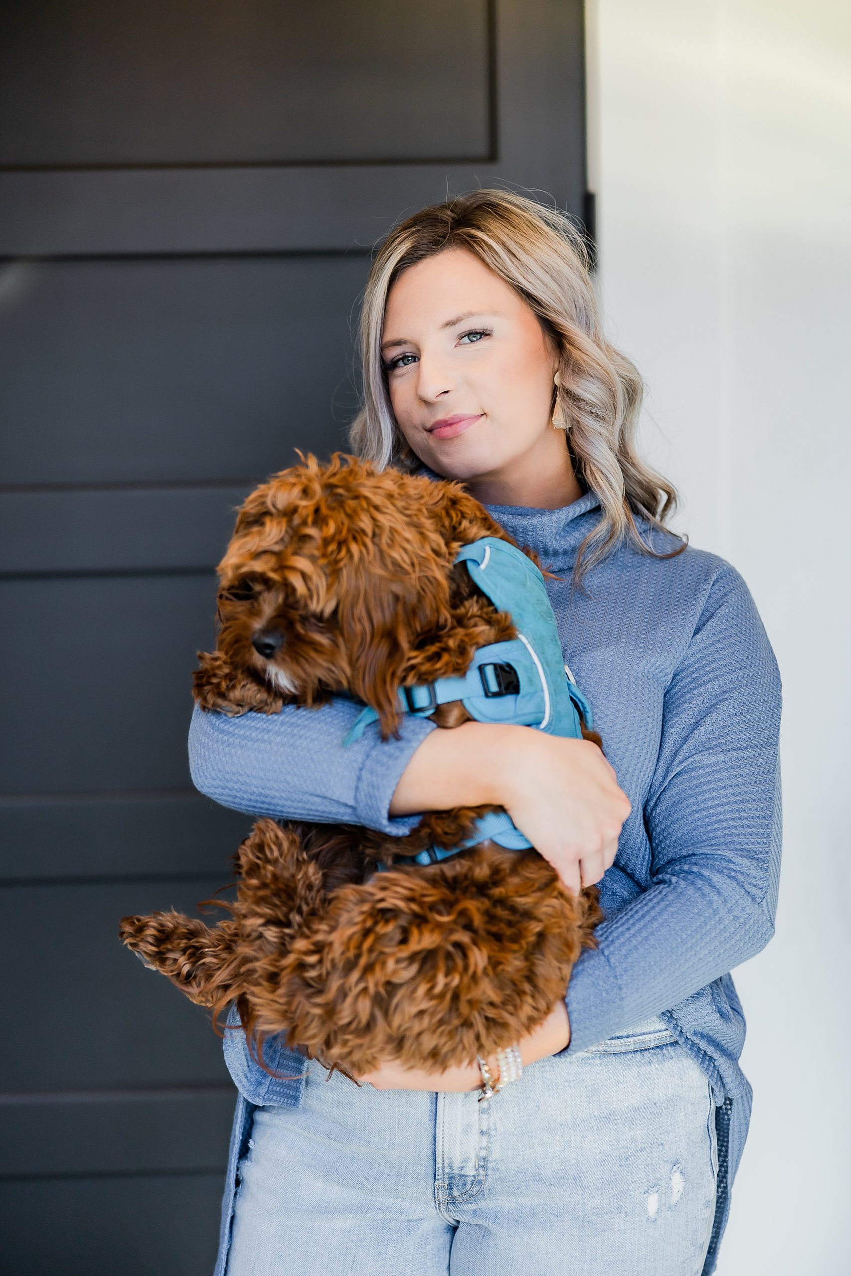 woman stands holding dog during branding session