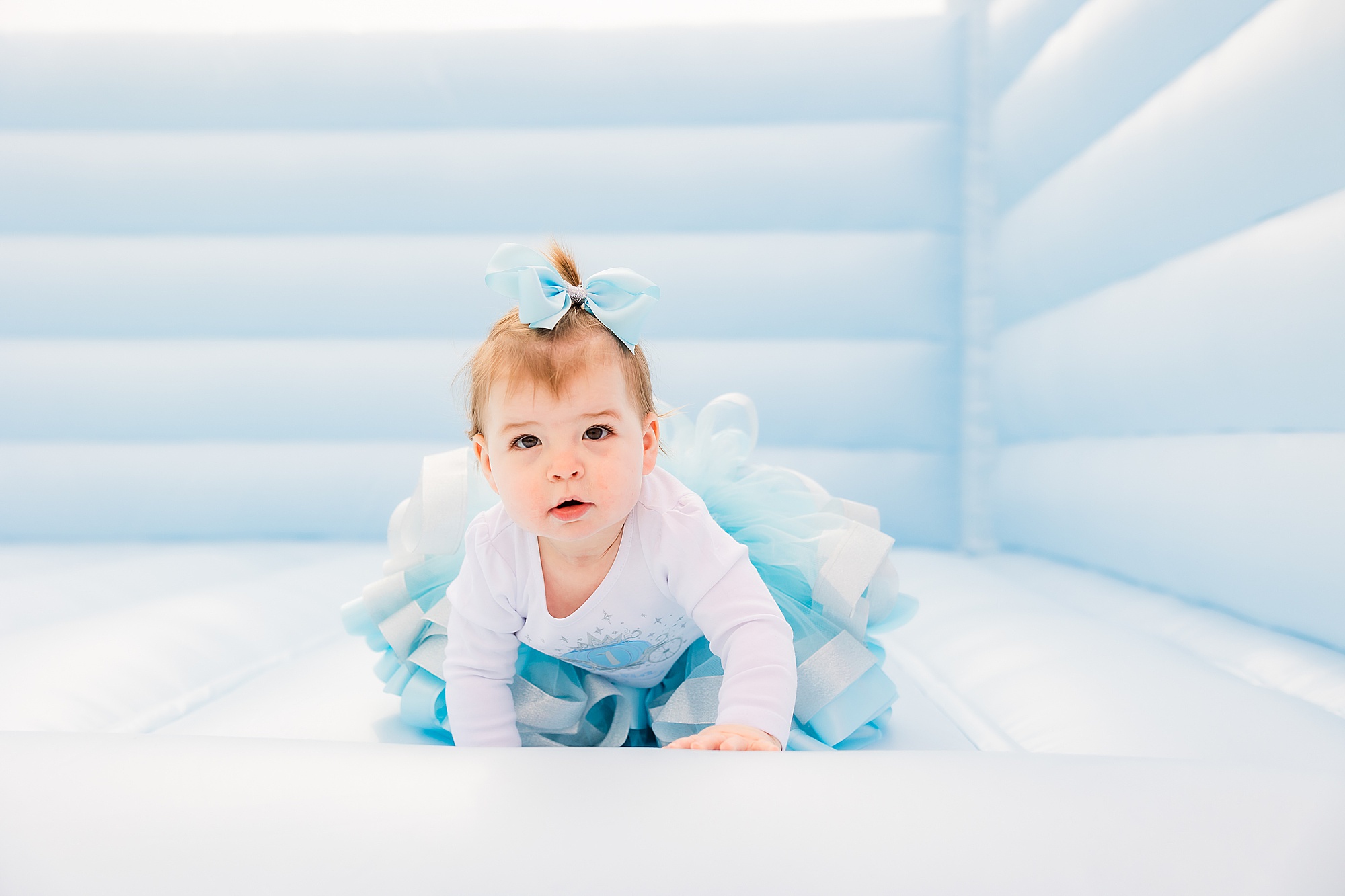 toddler crawls in bounce house during Princess themed first birthday party
