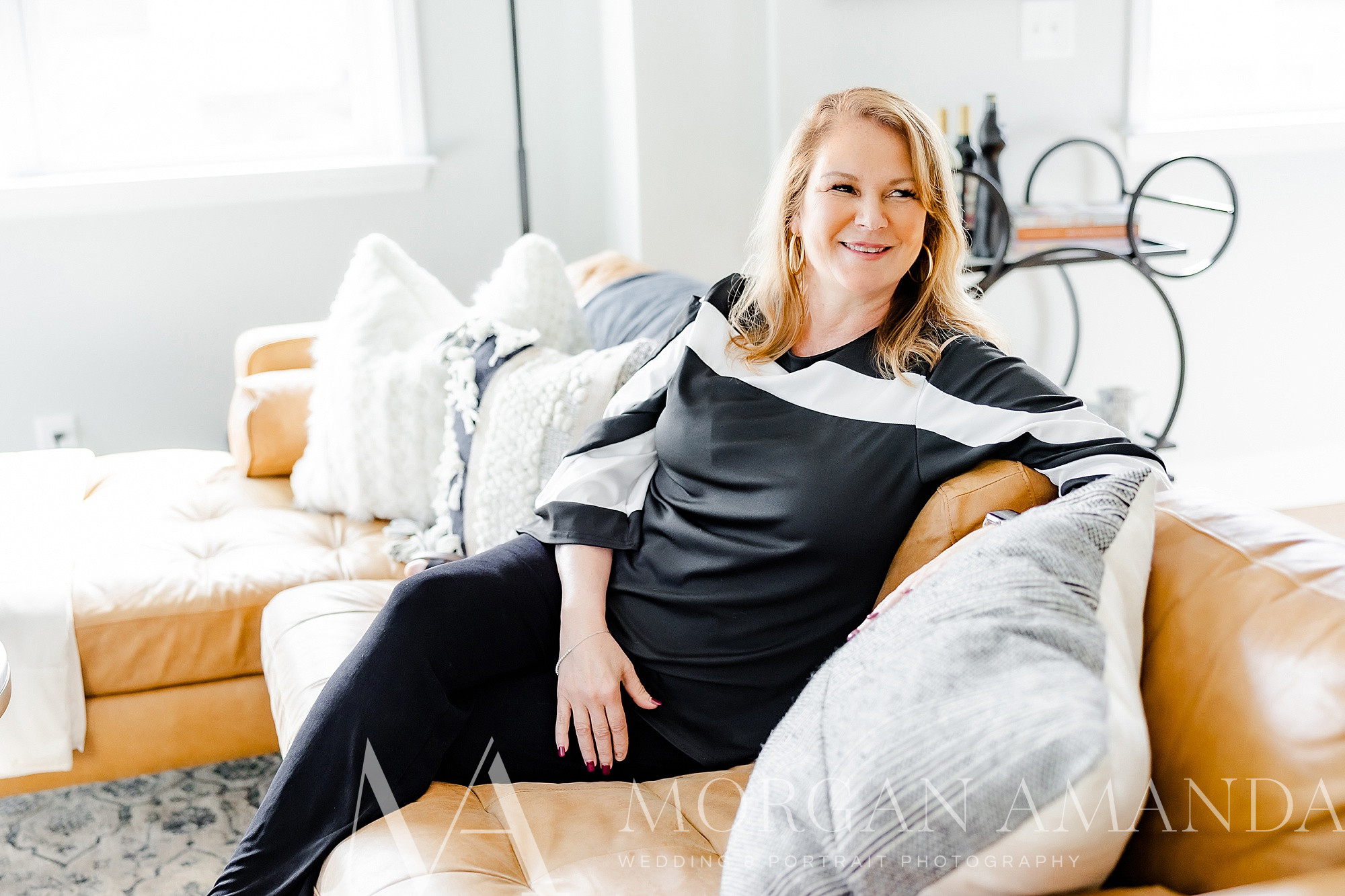woman sits on couch during branding photos at home 