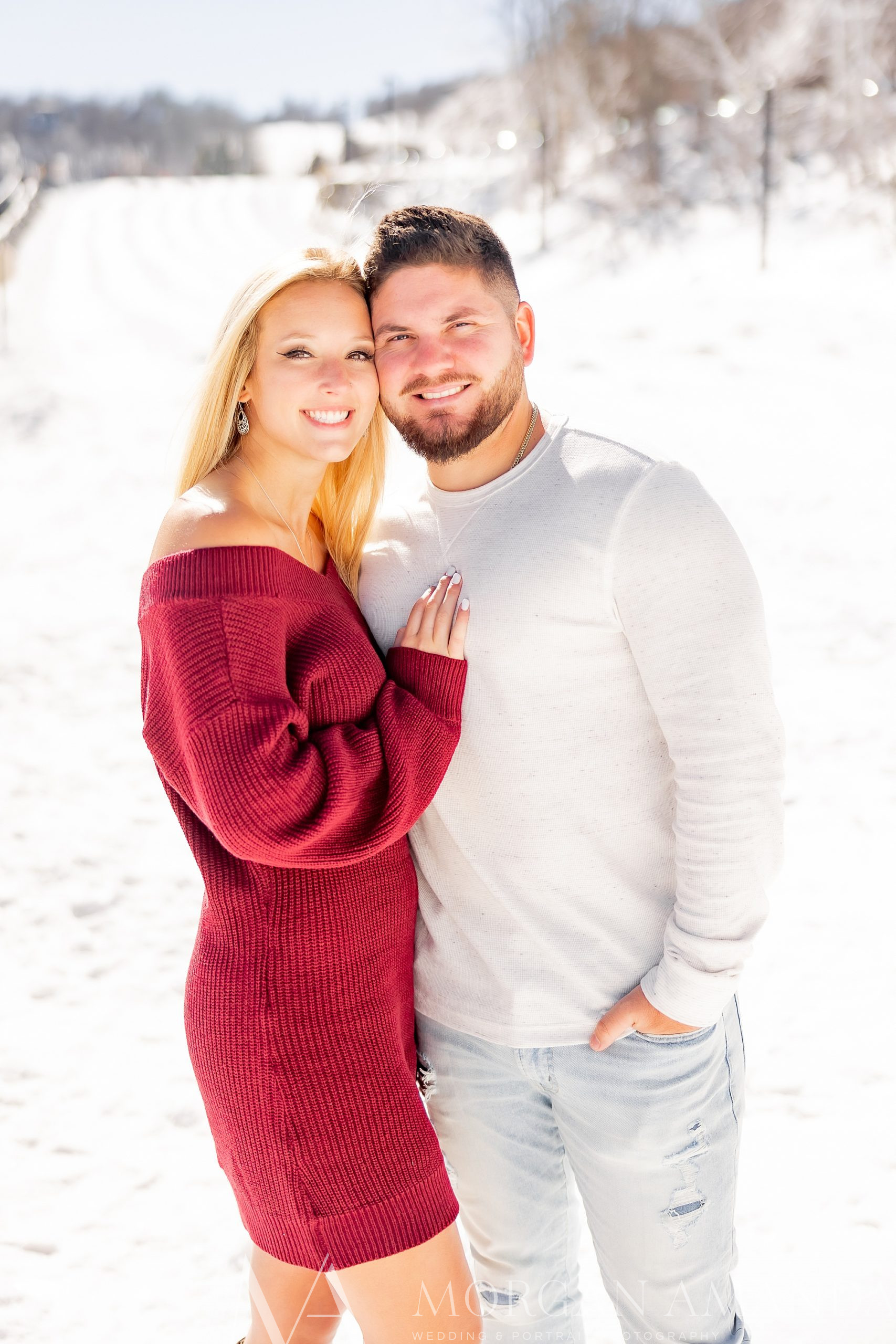 engaged couple hugs on side of mountain at Beech Mountain