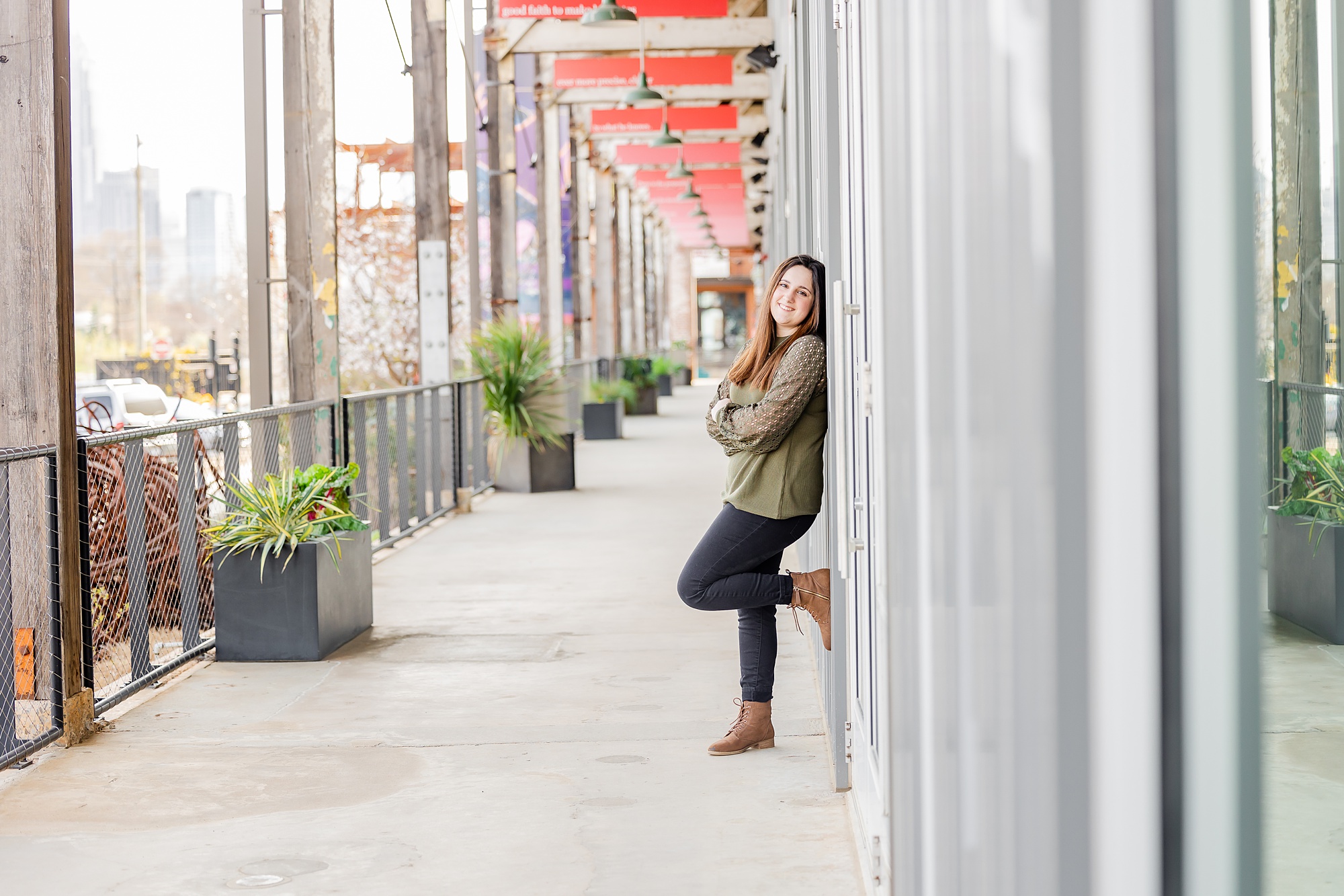 girl leans against doors during Camp North End senior portraits