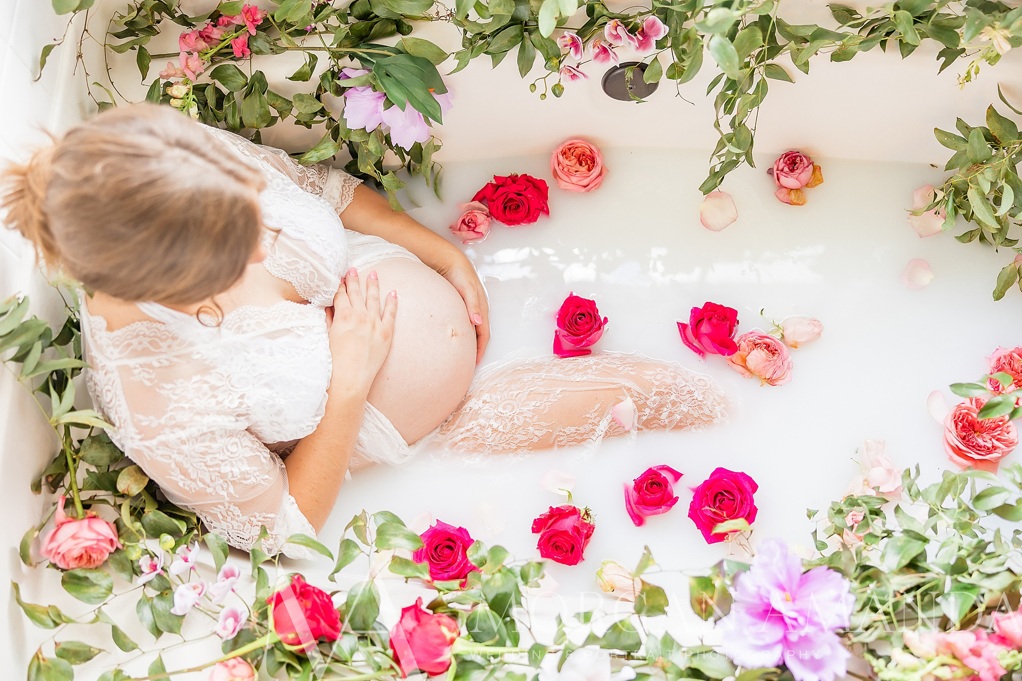 woman rests in tub with flowers around her during milk bath