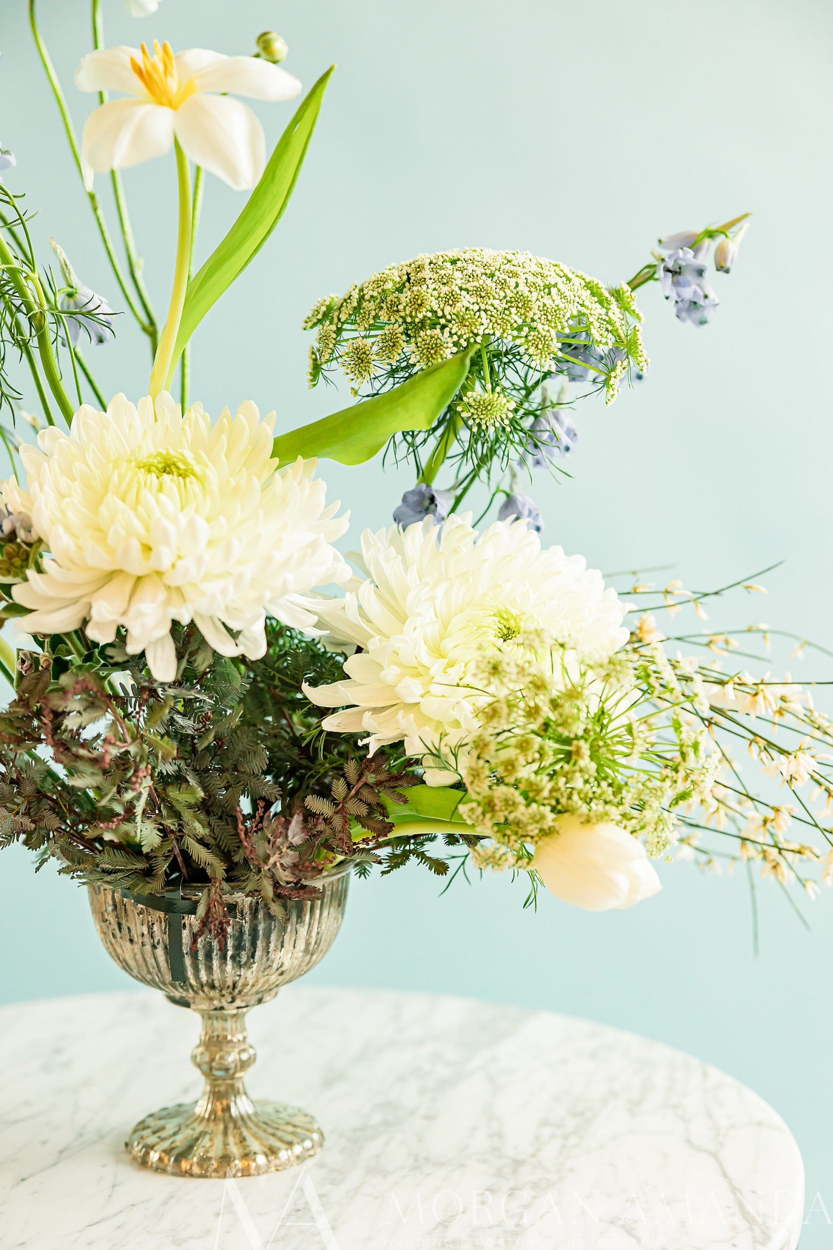 floral arrangement wit green and white flowers in gold container