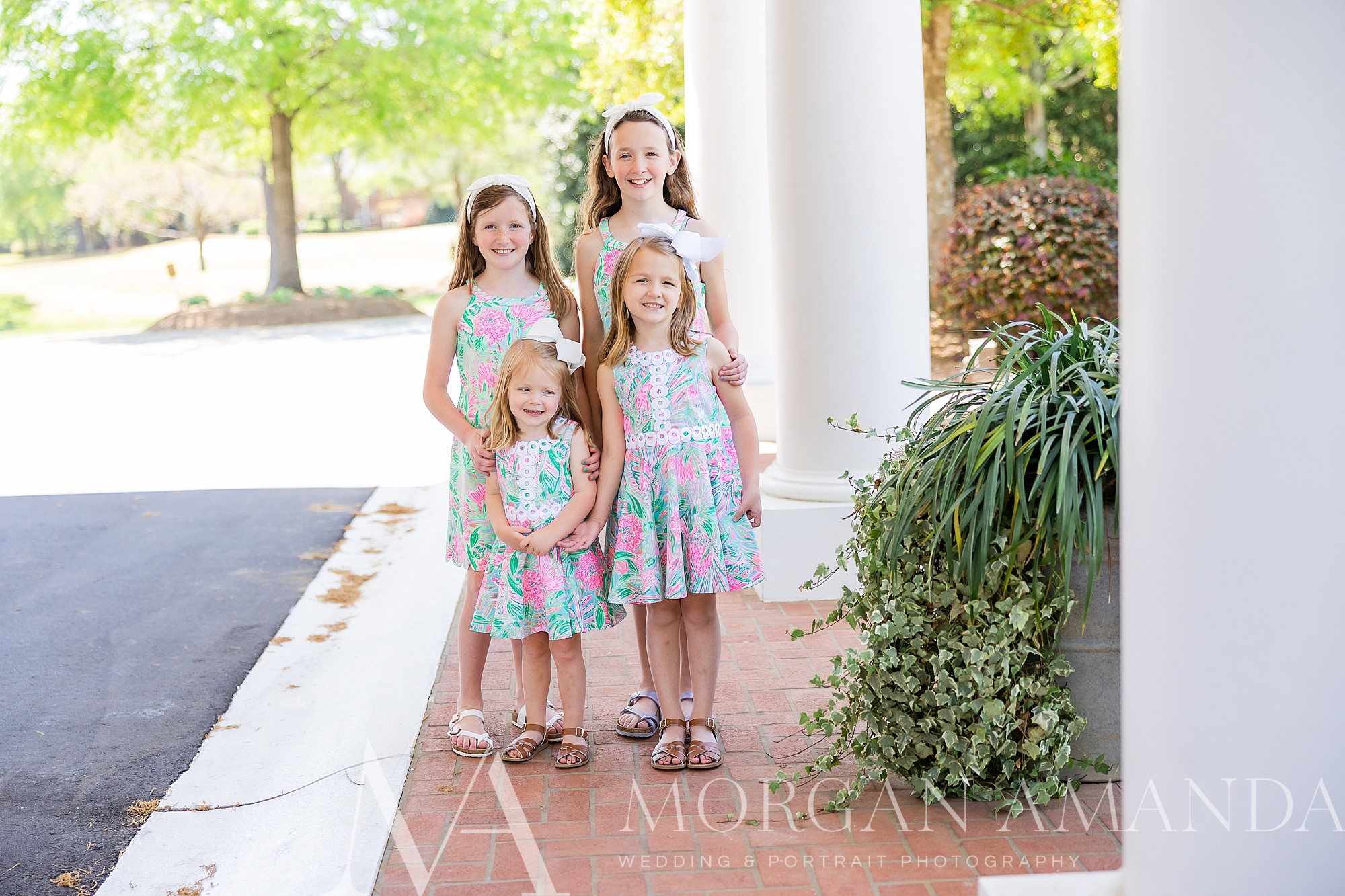 four sisters stand in Lily Pulitzer dresses at Providence Country Club