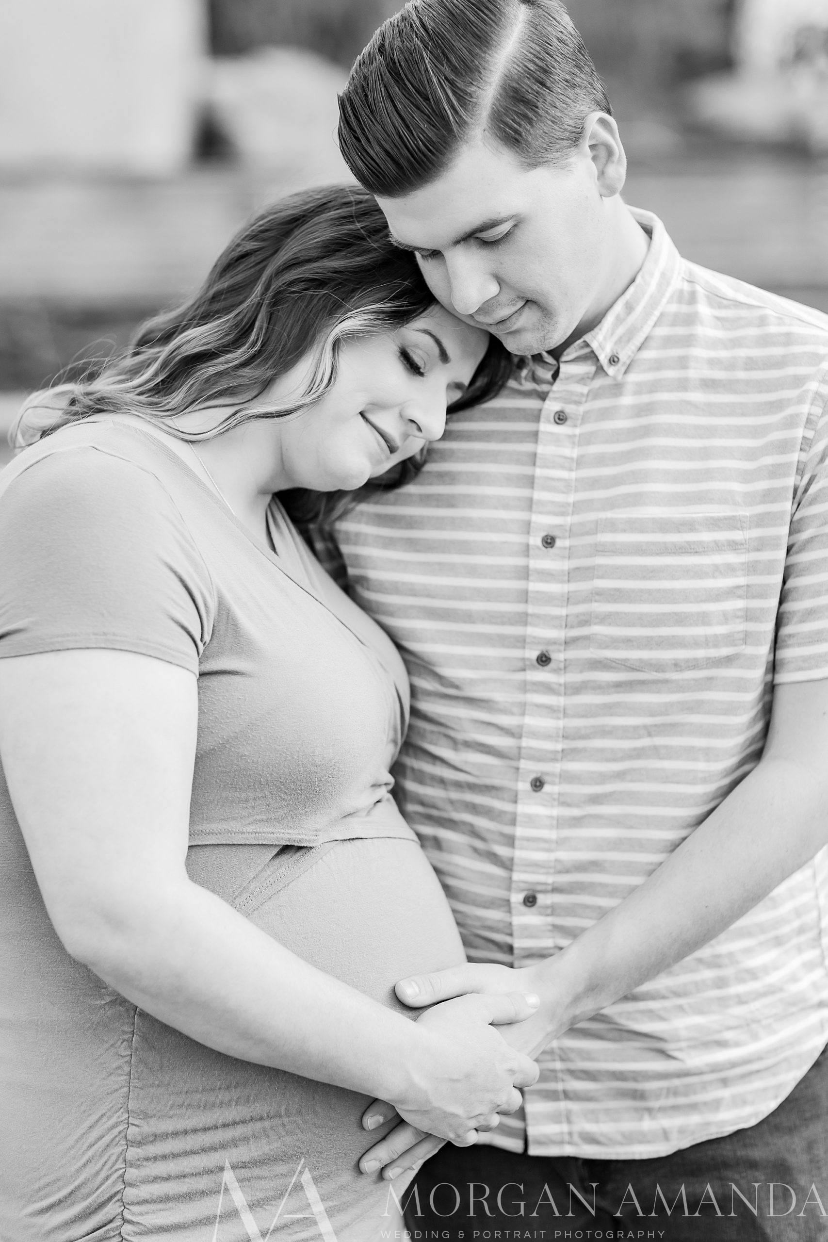 woman leans on husband during Romeare Bearden Park maternity session