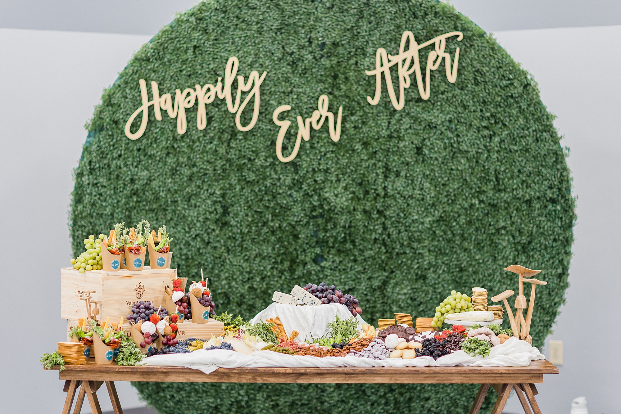 happily ever after sign on greenery wall by dessert table
