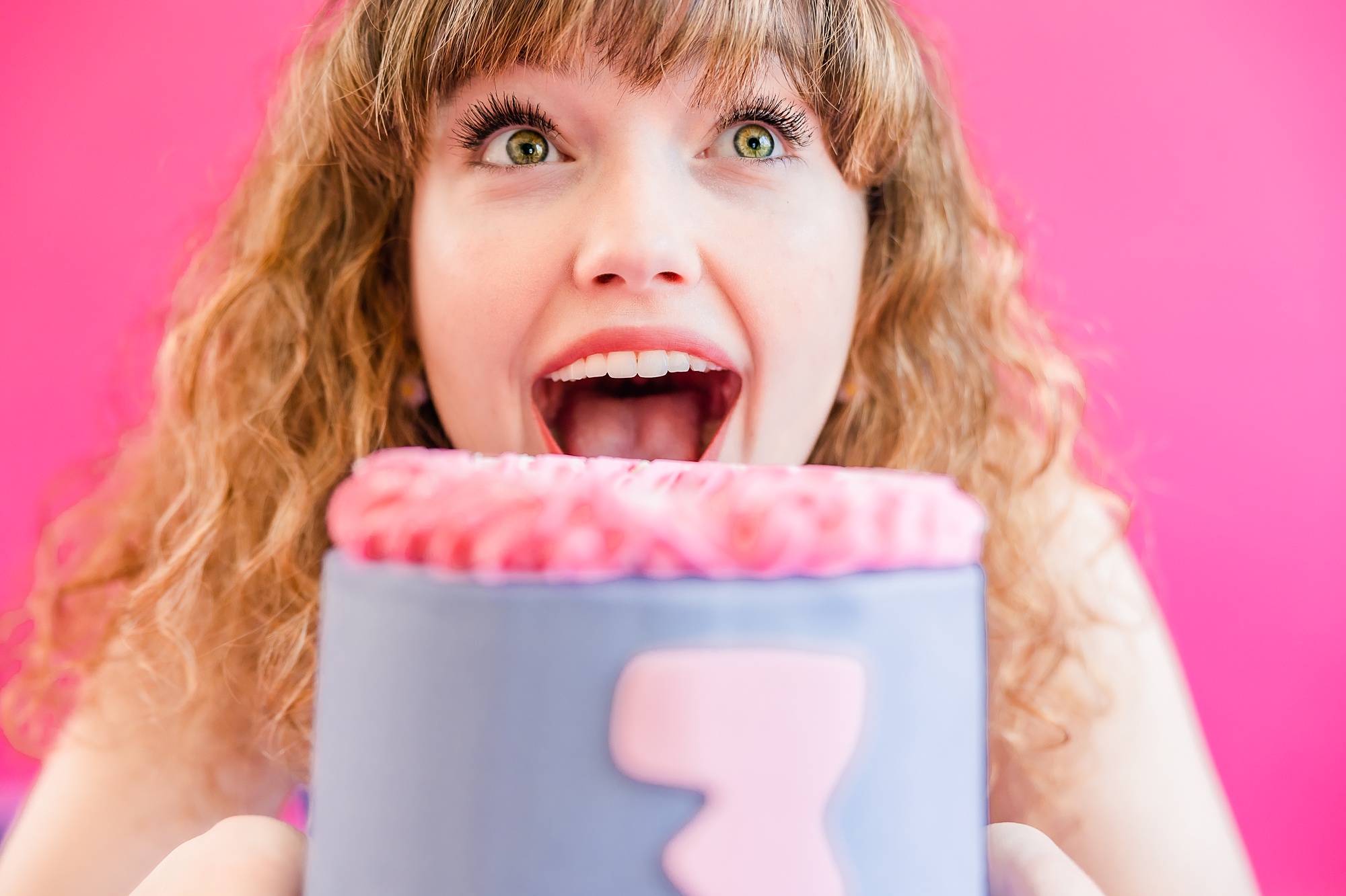 woman laughs about to bite cake during nplayful branding portraits