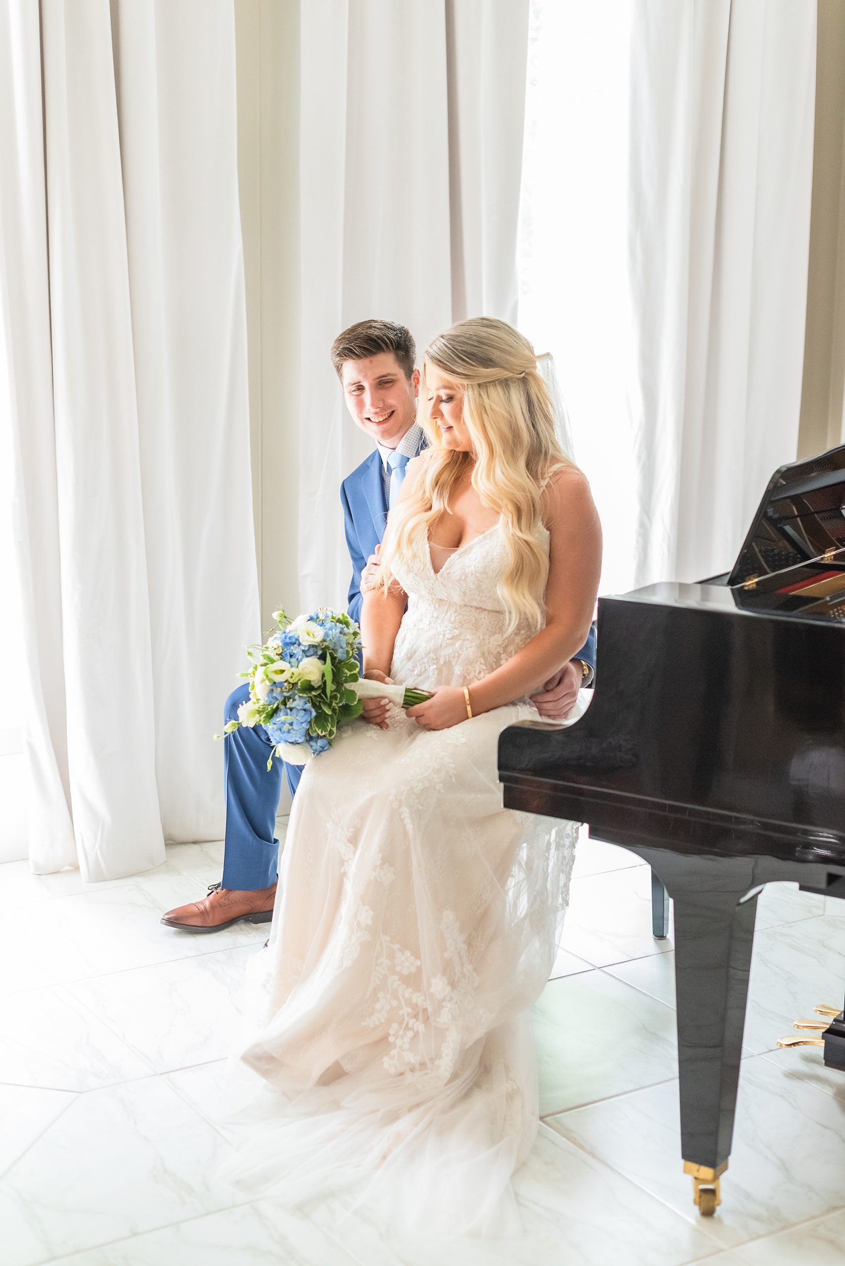 bride and groom sit by piano at Victoria Belle Mansion