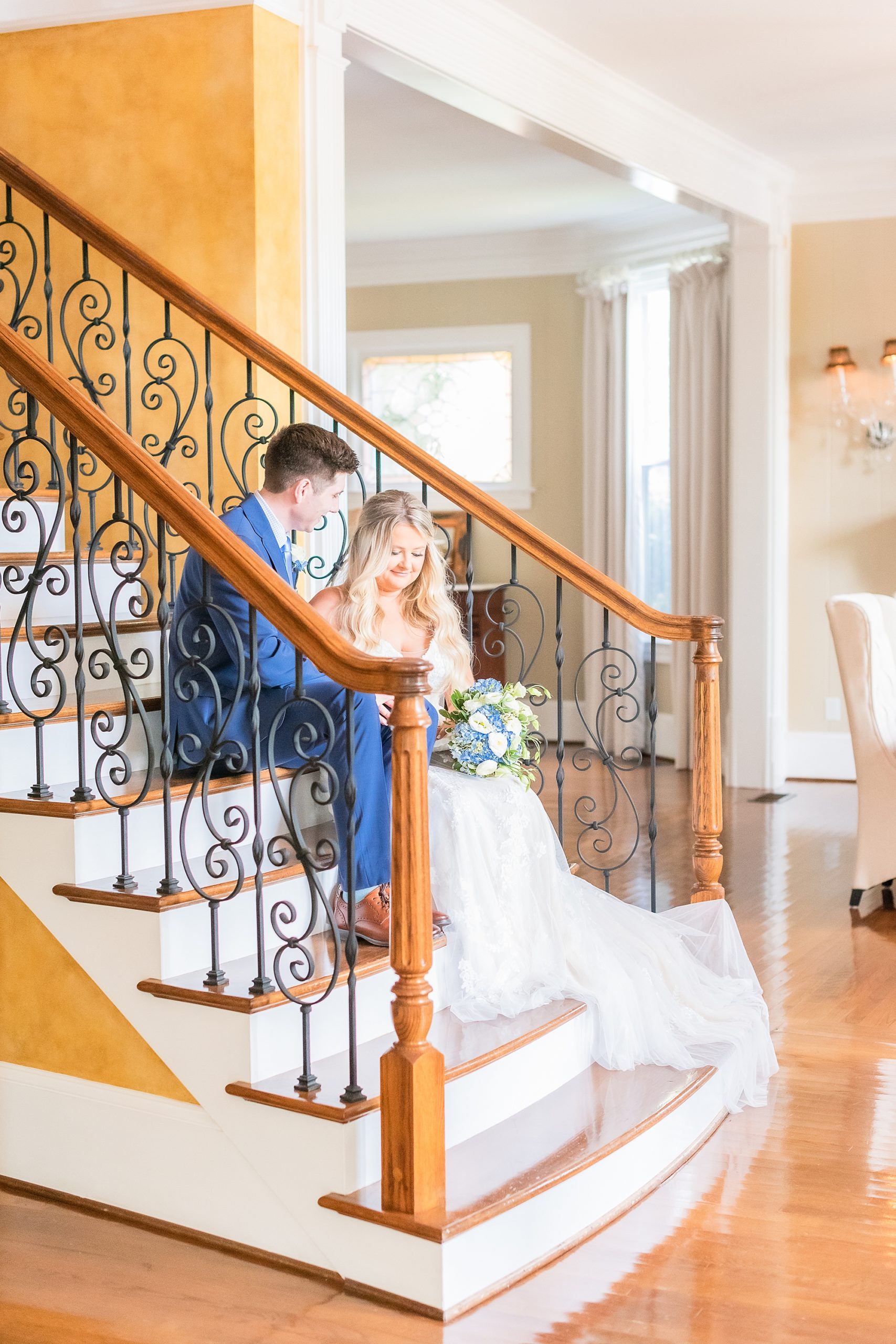 bride and groom sit on steps inside the Victoria Belle Mansion