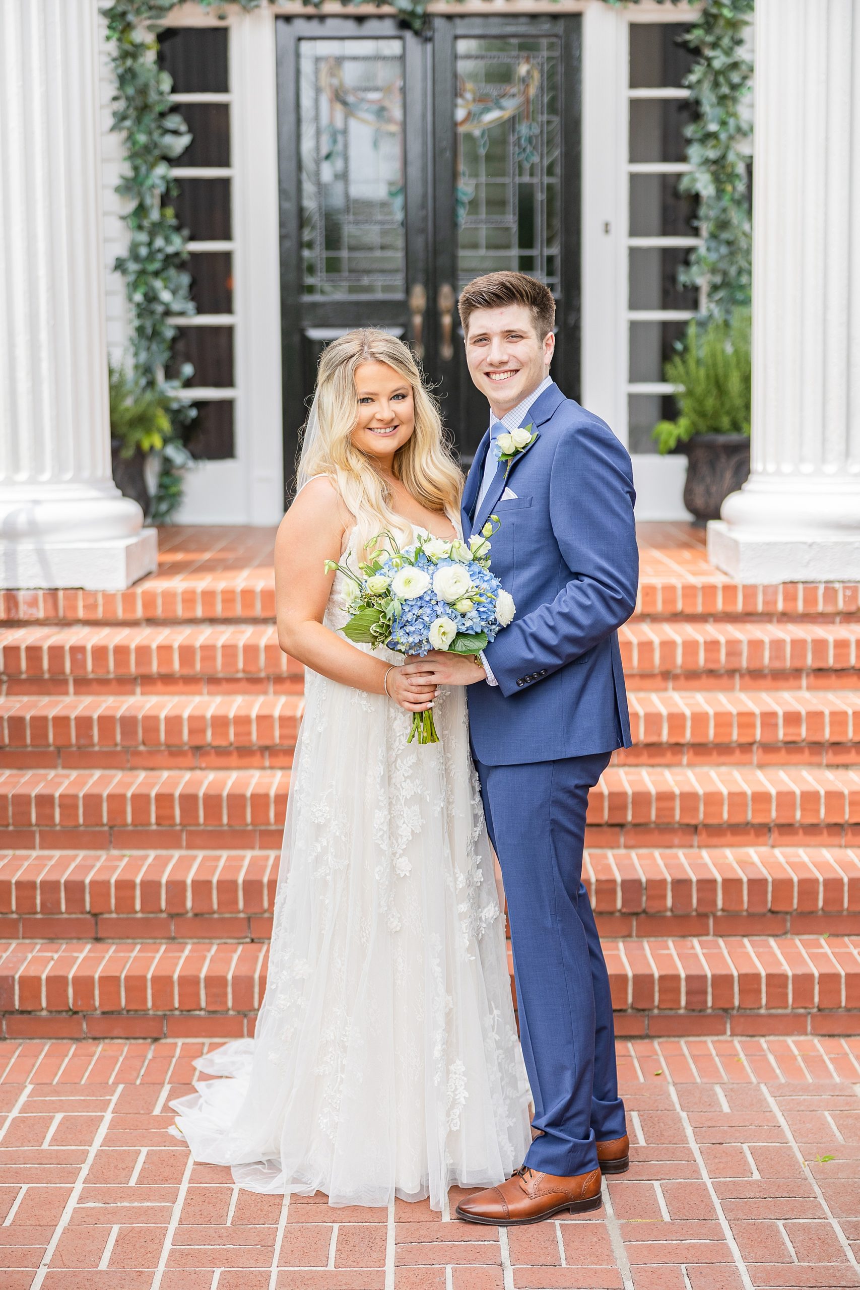 newlyweds stand on brick patio at Victoria Belle Mansion