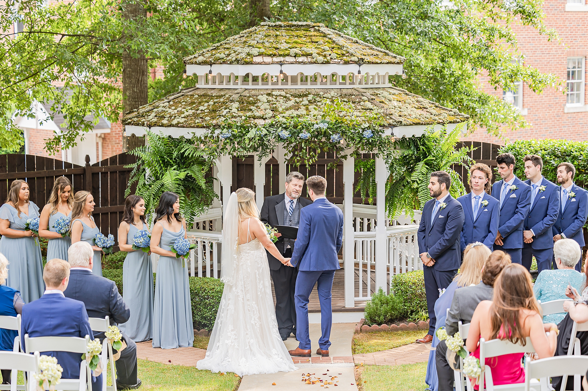 bride and groom hold hands at gazebo