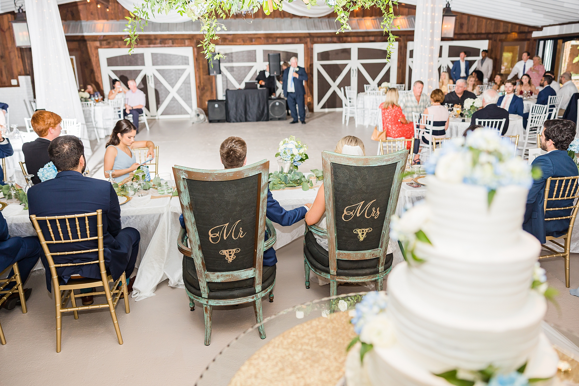 Vintage White Barn wedding reception with sweetheart table chairs