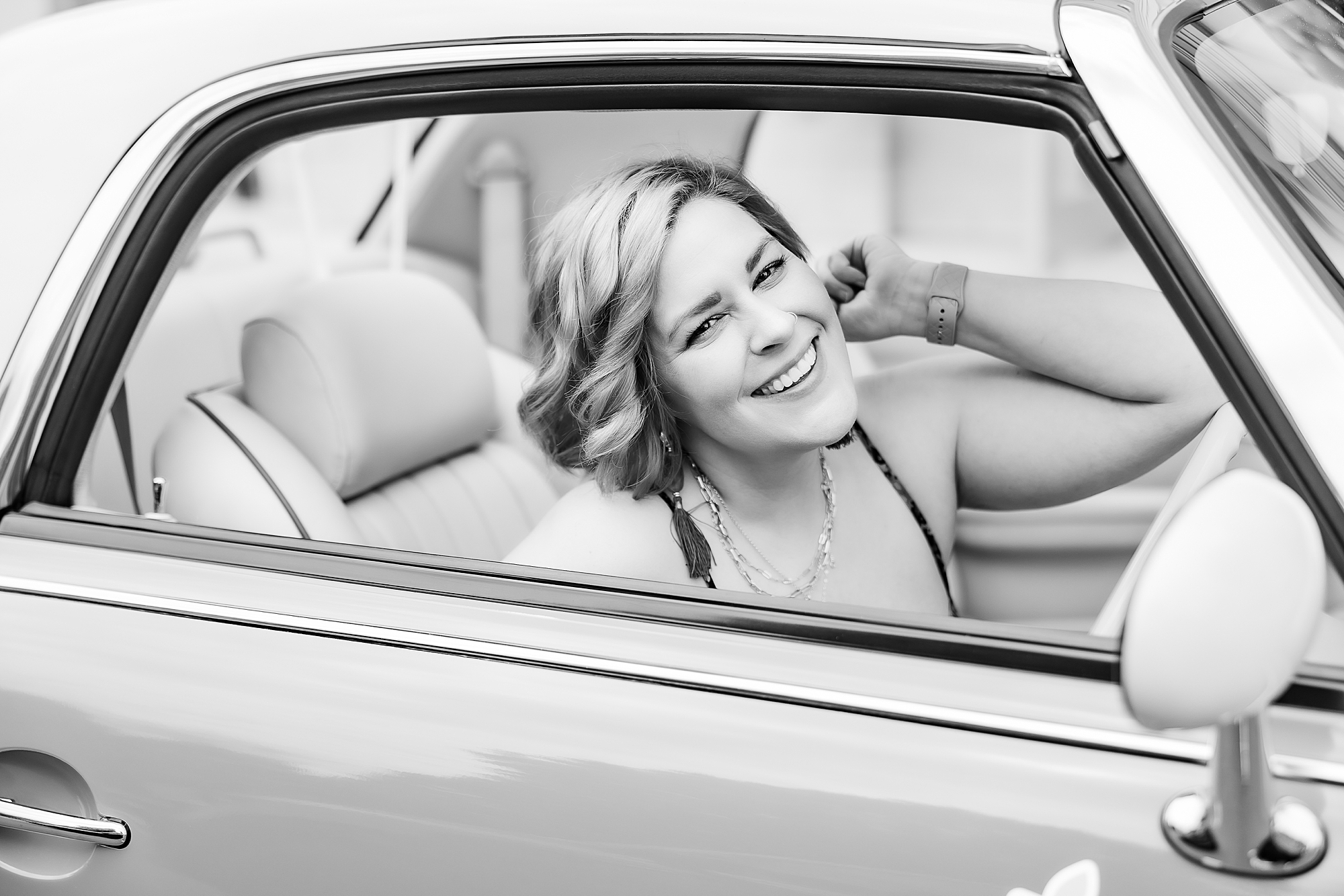 woman smiles looking out car window during branding photos in Birkdale Village
