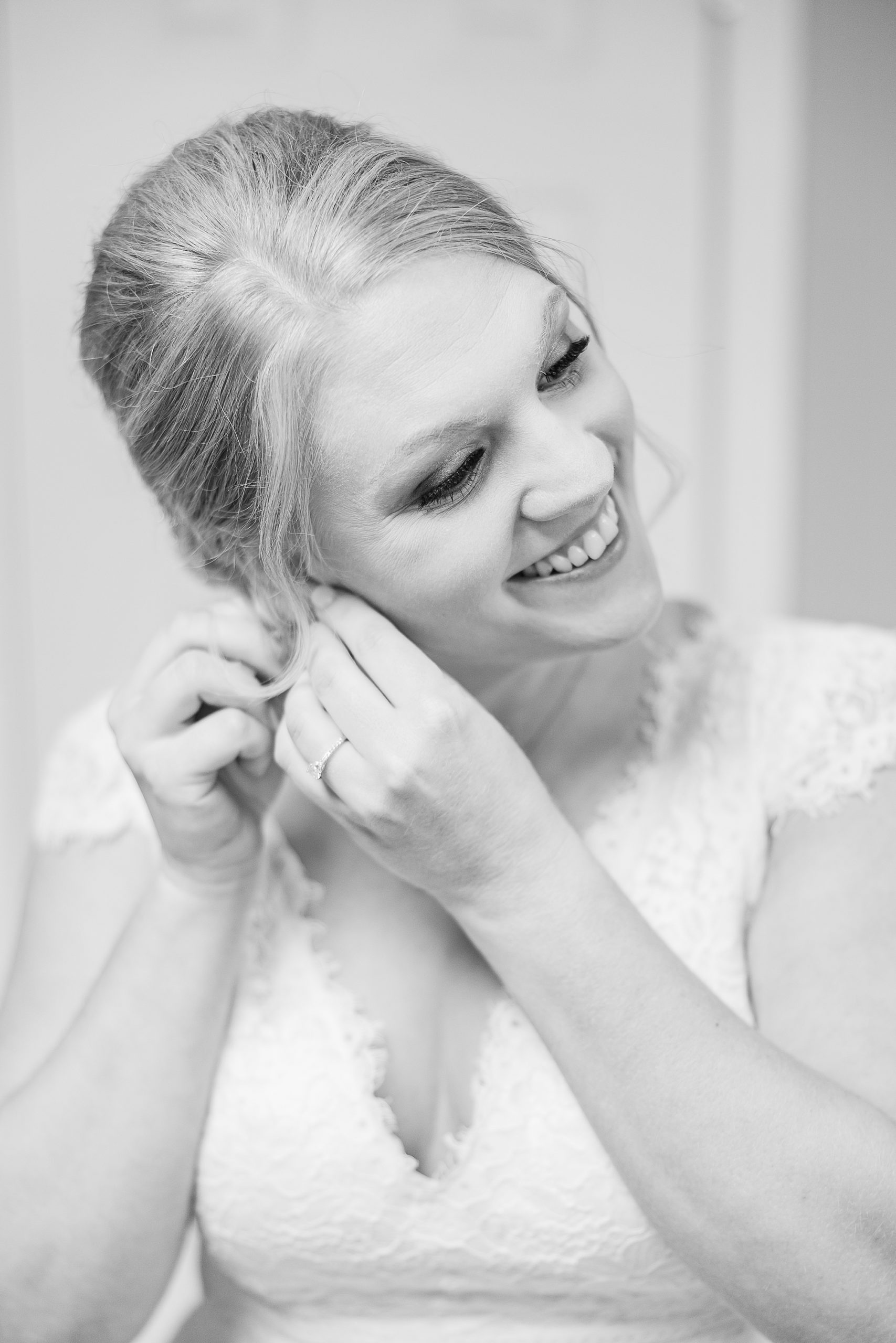 bride leans head down adjusting earrings