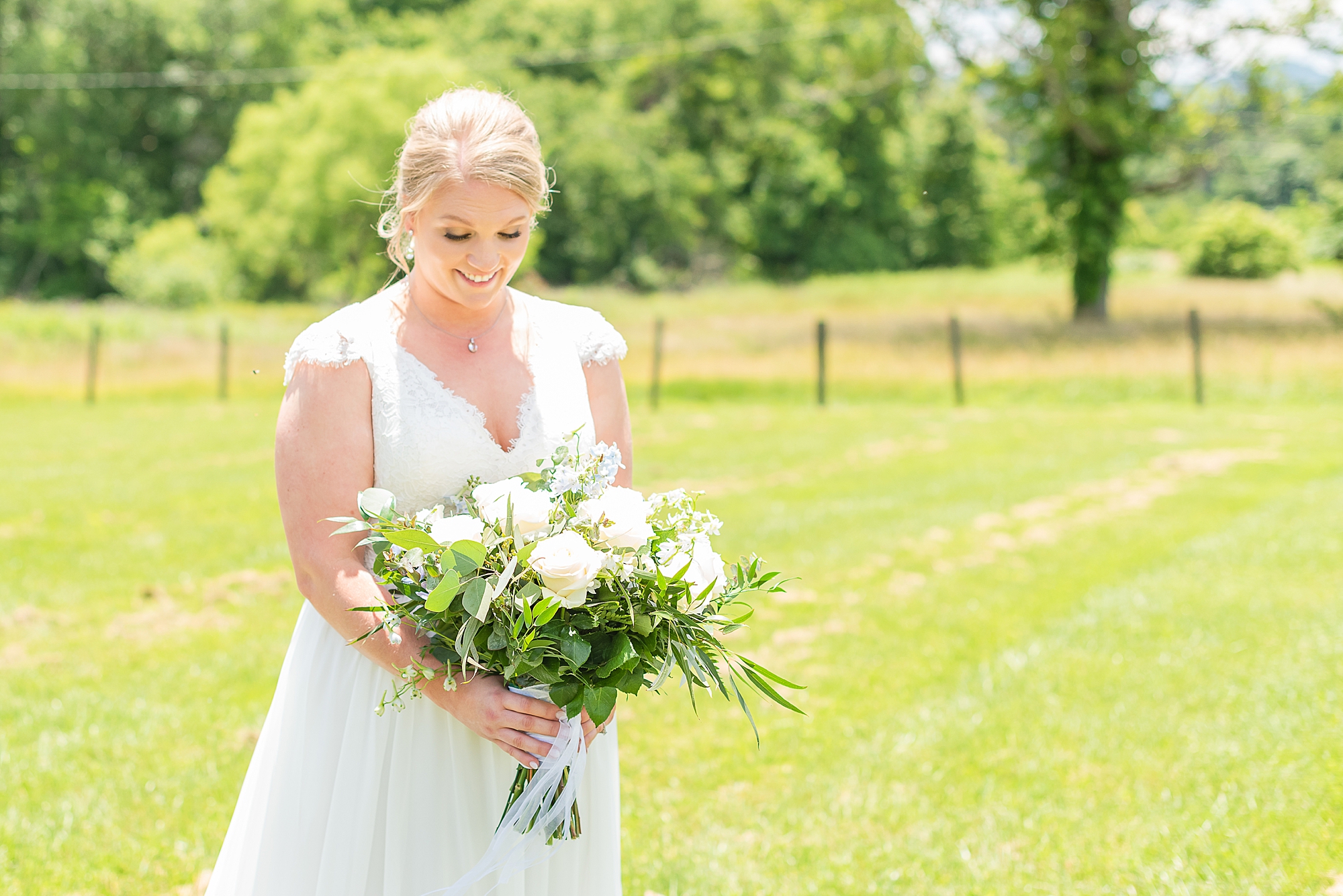 bride looks down at bouquet of yellow flowers