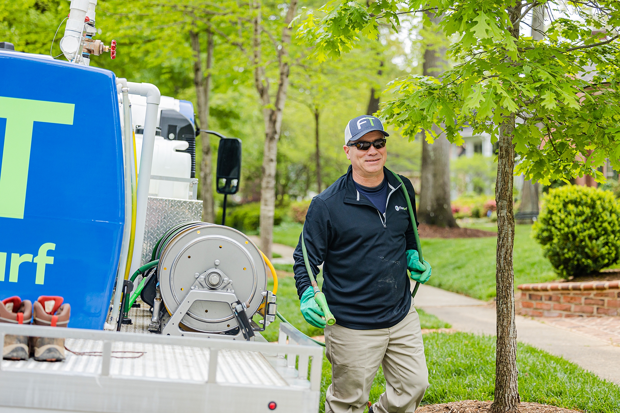 man moves hose during Charlotte branding session for lawn care company 