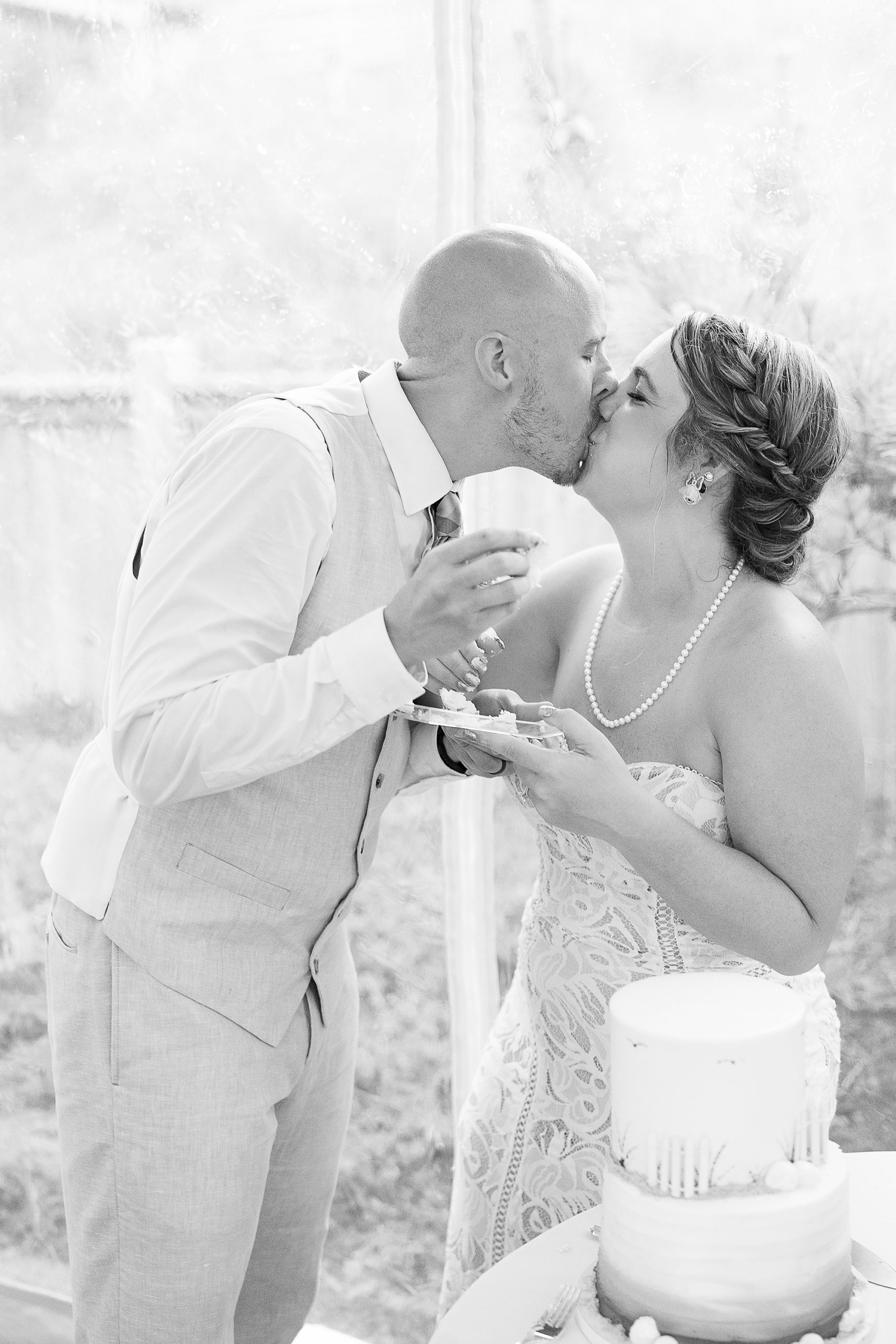 newlyweds kiss during wedding cake cutting 