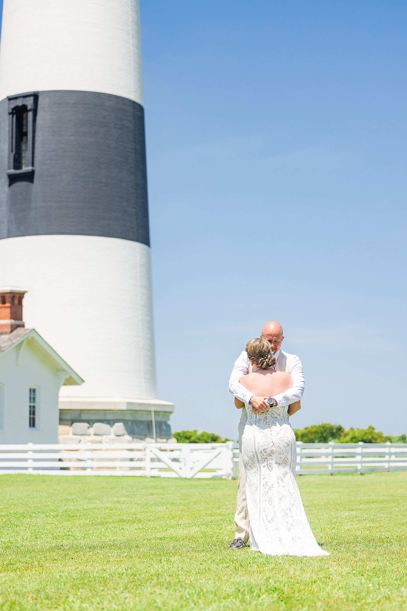 newlyweds hug during first look by Bodie Lighthouse 