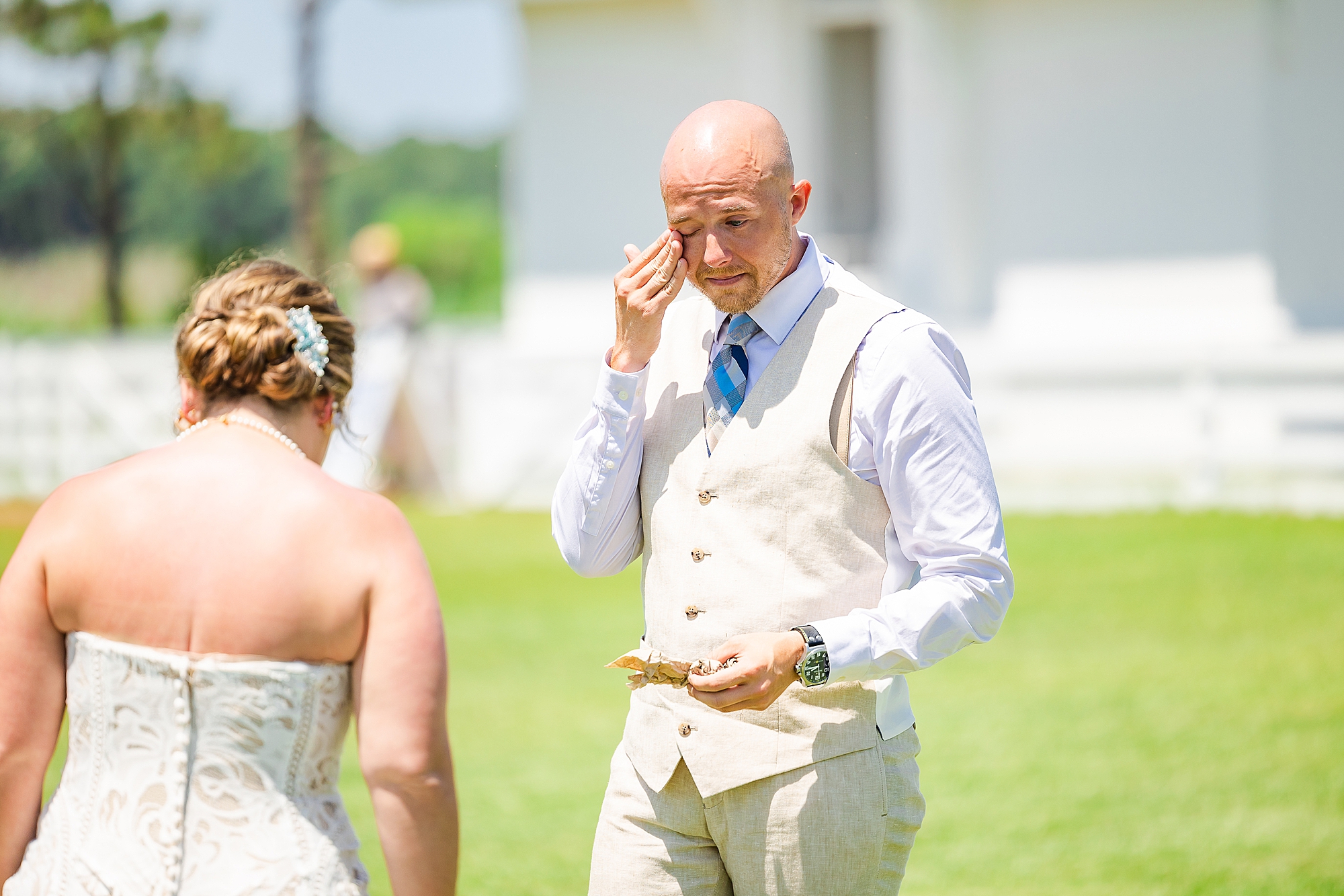 groom wipes away tear during first look by Bodie Lighthouse 