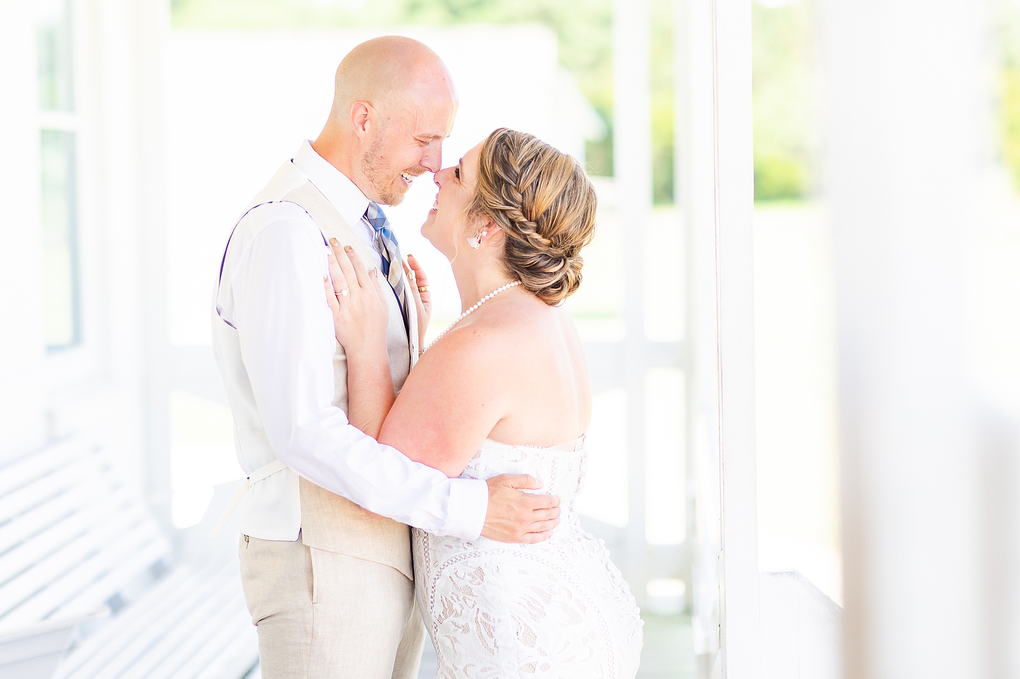 bride leans into groom during portraits on front porch