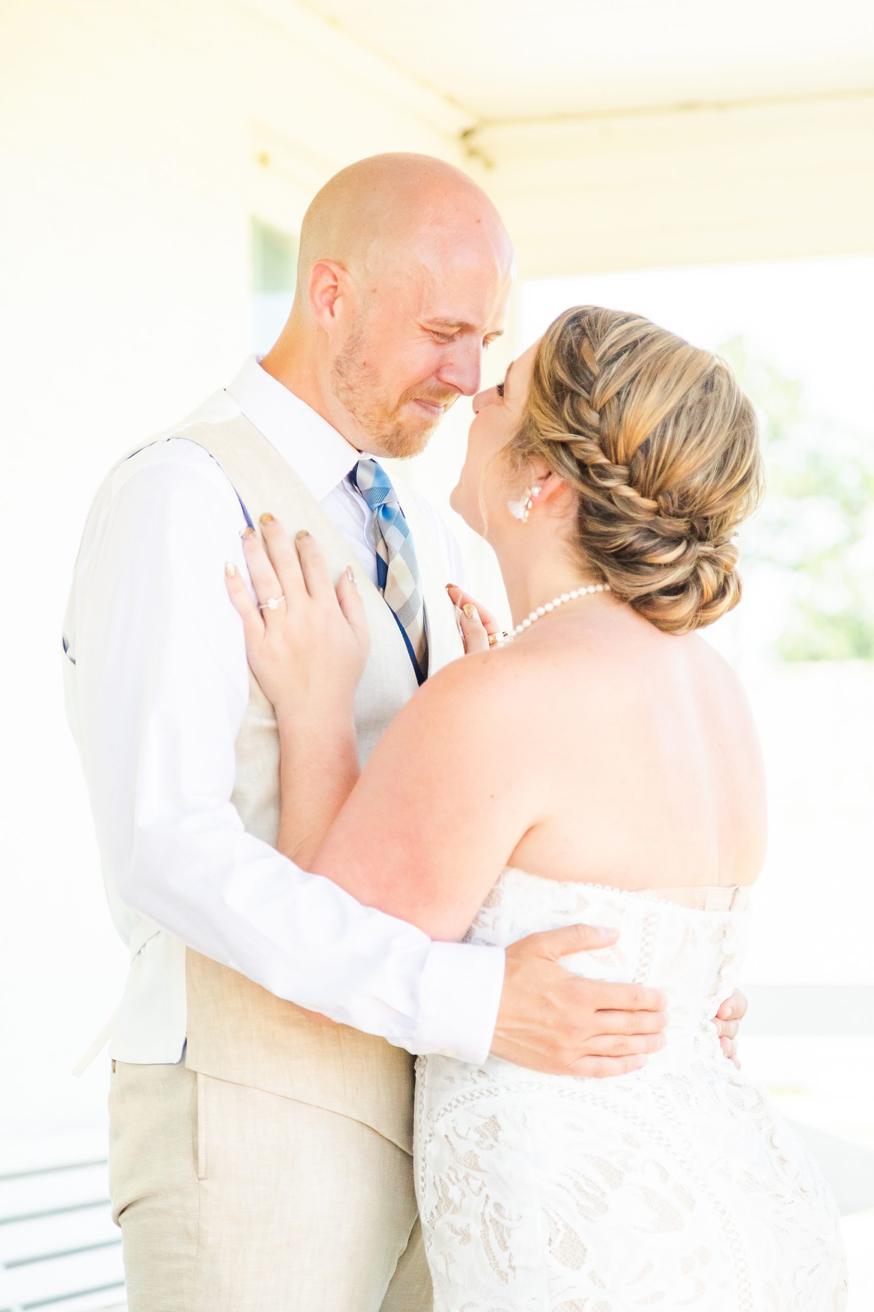 newlyweds hug on porch at Outer Banks