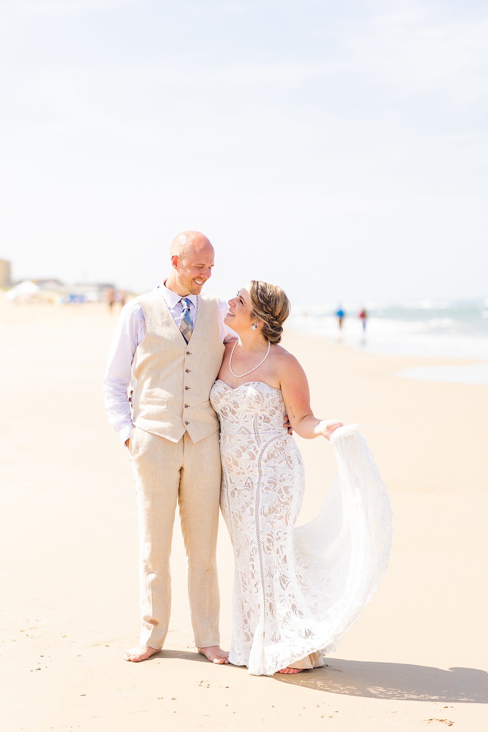 bride and groom walk on beach during portraits 