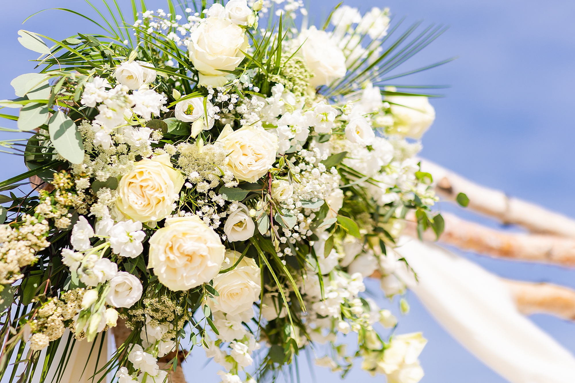 white and yellow floral display on arbor for OBX wedding ceremony