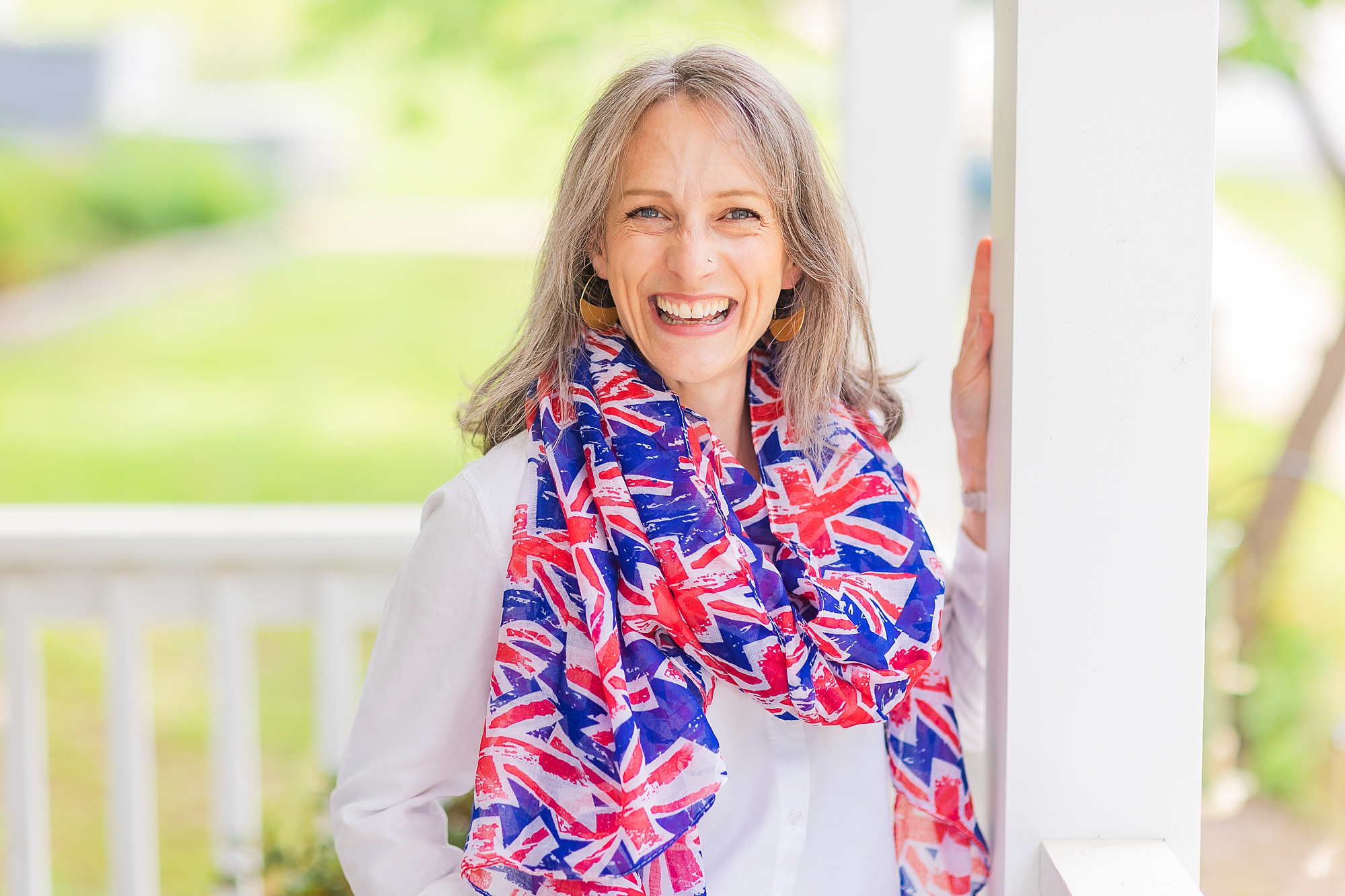 woman stands on porch in scarf with British flag