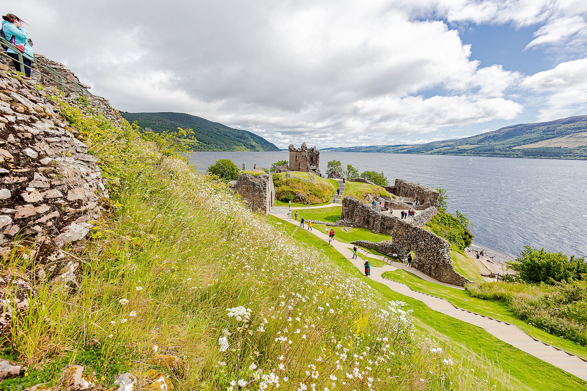 Scottish countryside with Urquhart Castle along water 