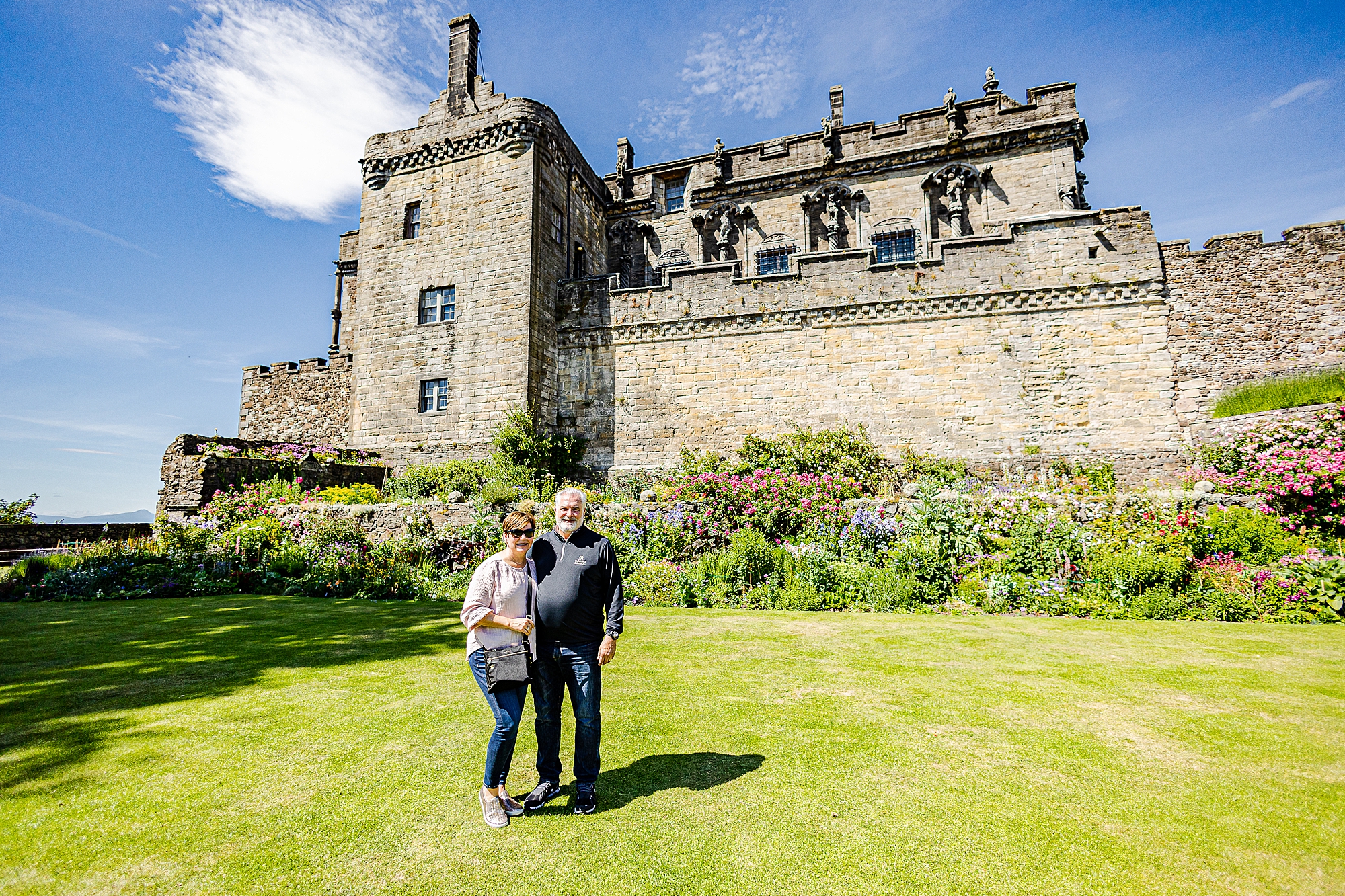 couple poses outside castle in Scotland 