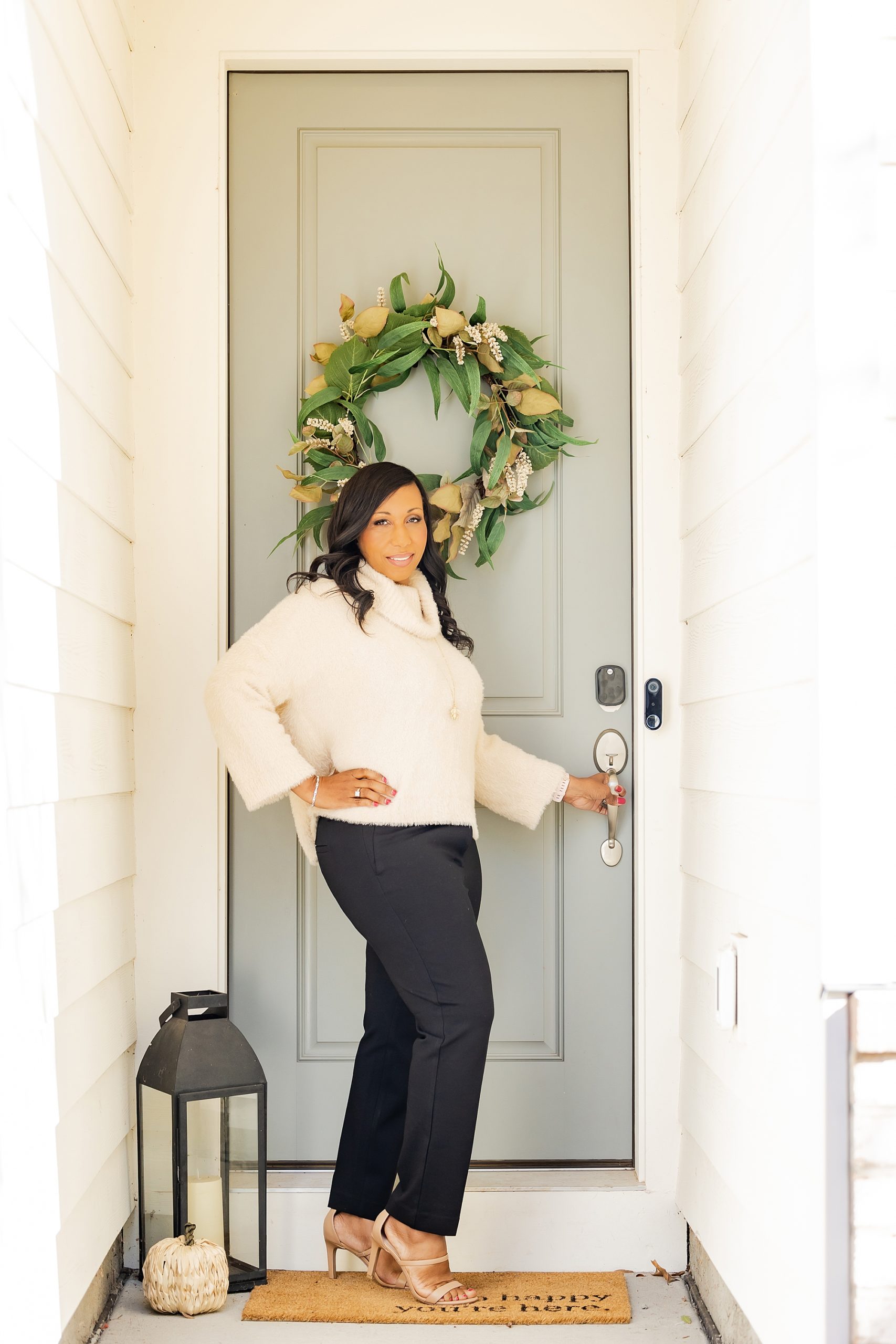 woman poses by front door during Charlotte branding session