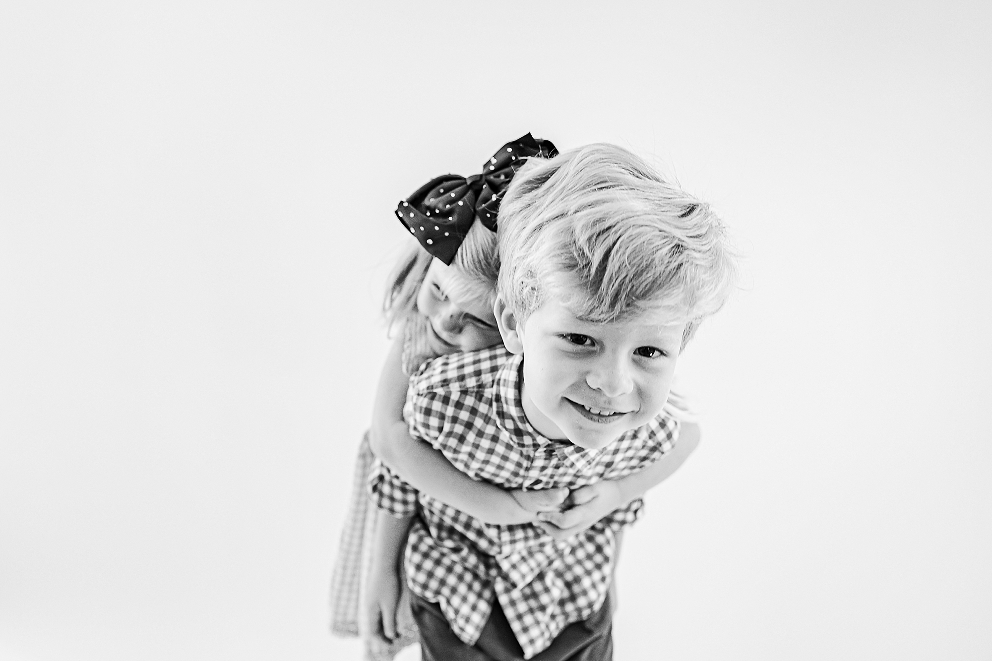 girl tackles brother during studio portraits 